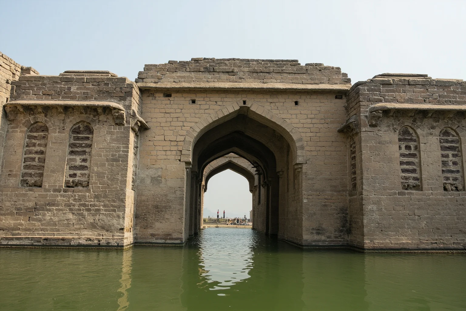 An old citadel gate and moat surrounding a walled imperial complex