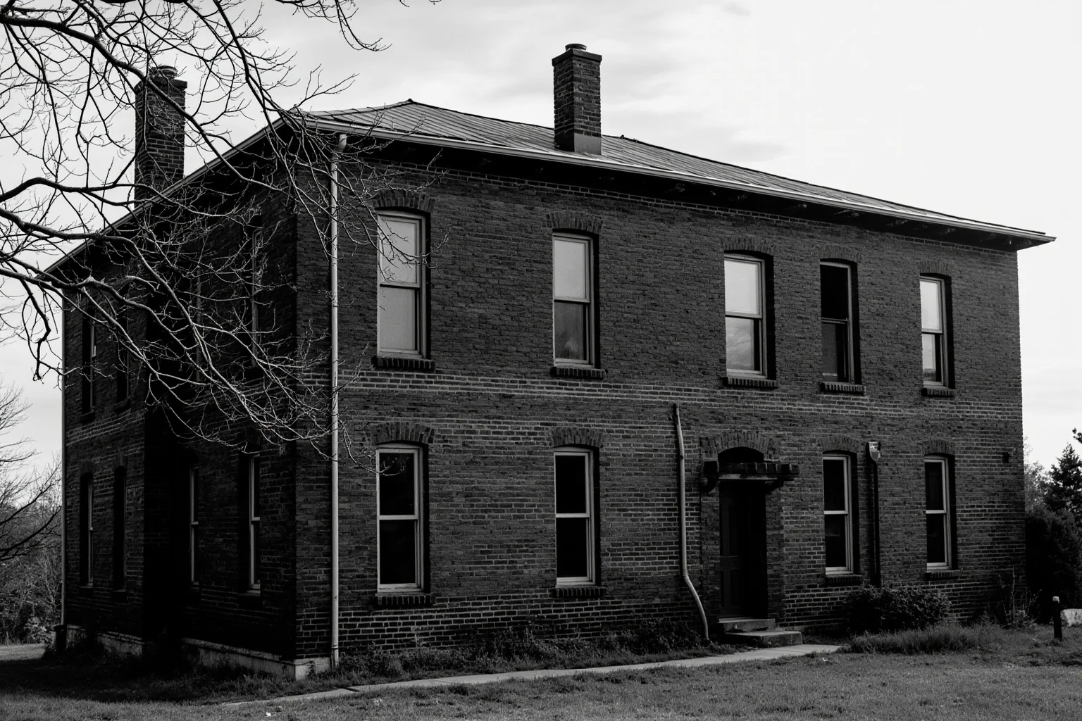 An old schoolhouse building with a somber, weathered look, symbolizing the boarding school era