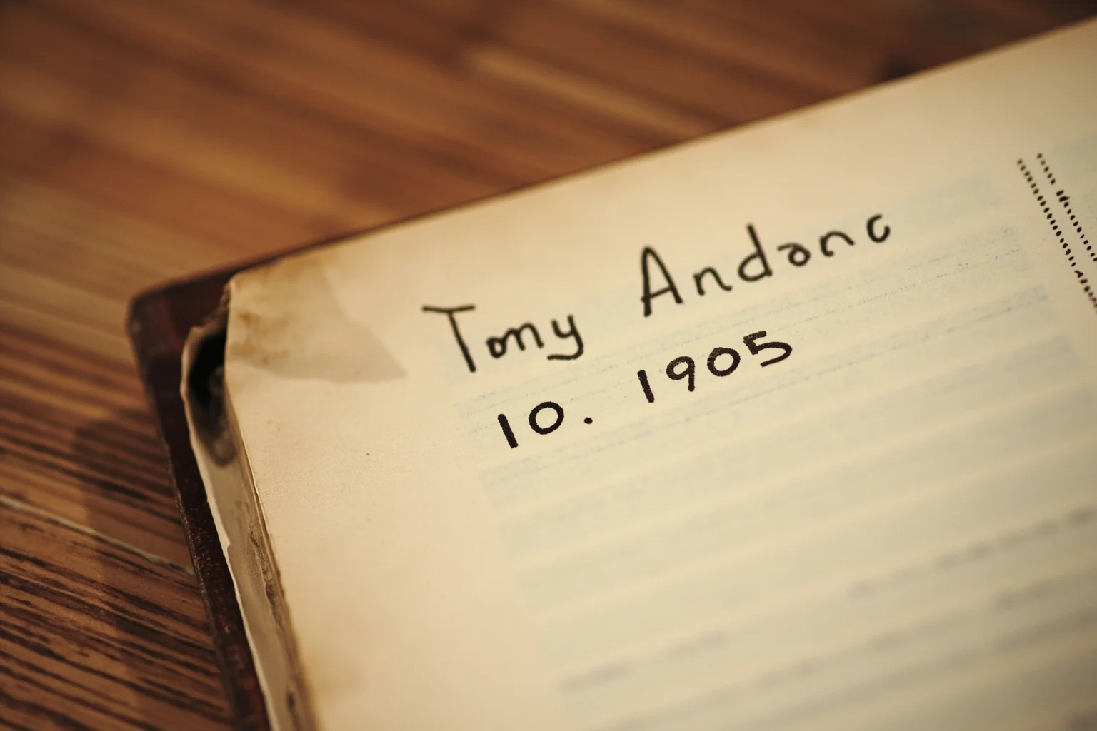 An old weathered family Bible page with a faded handwritten name and birth date from 1905
