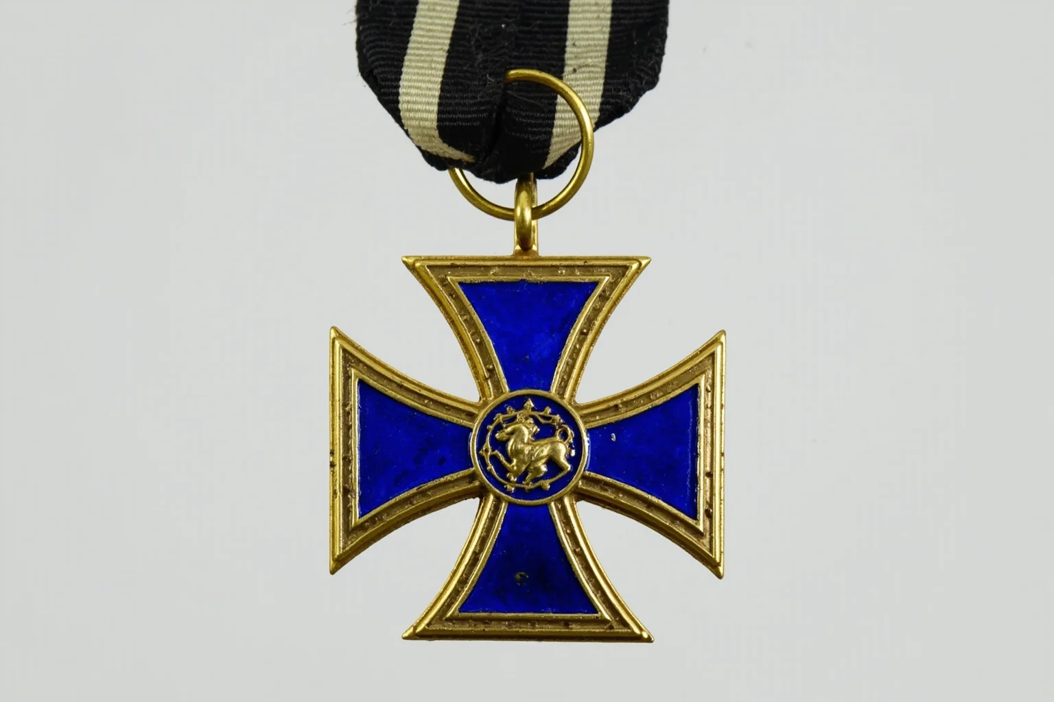 Highest Military Decorations: 20 Rare and Obsolete Medals You'll Never See Again 5 An ornate blue-and-gold enameled cross medal hanging from a black-and-white ribbon, styled like an early 20th-century European military order