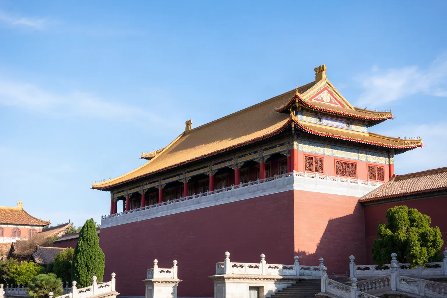 An ornate Forbidden City-style palace complex with red walls and golden roofs under a clear sky