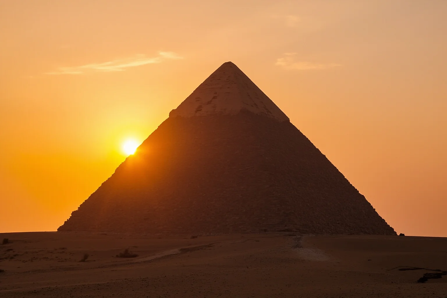 Wide shot of the Great Pyramid of Giza at sunset with construction ramps illustrated faintly in the sand