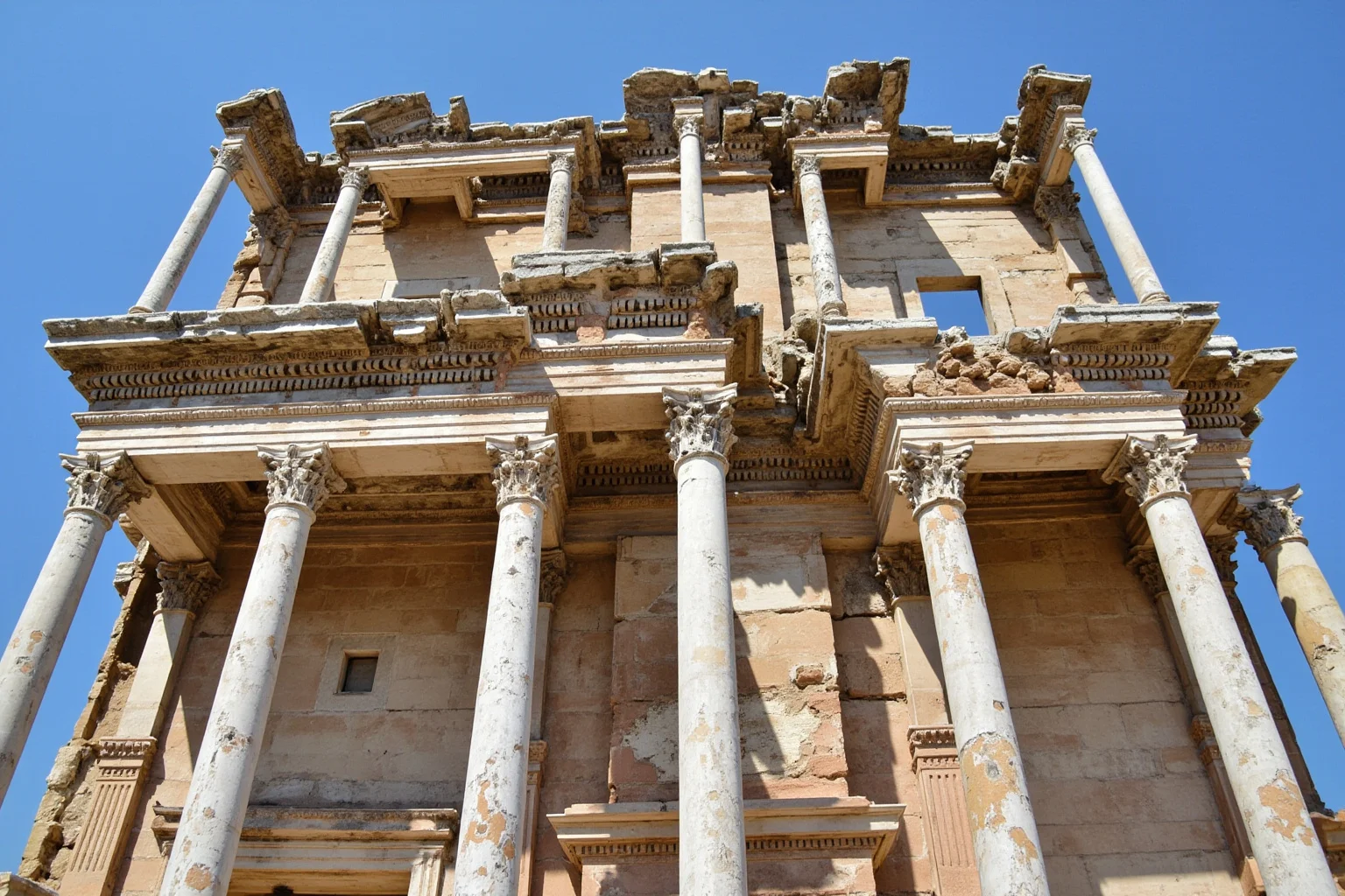 Ancient marble library facade with tall columns at a Roman-era ruin site