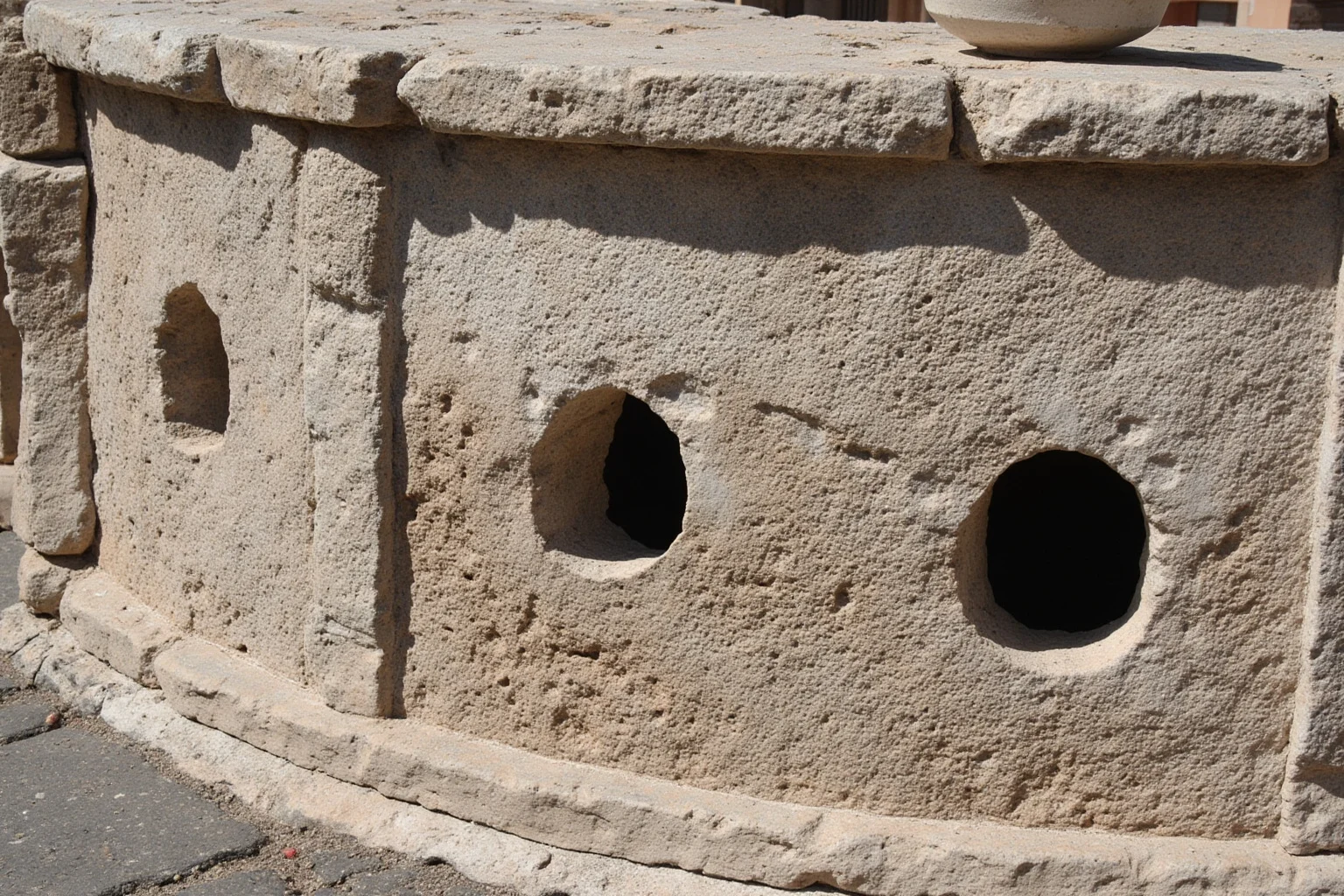Ancient Roman street food counter with round holes for serving containers built into stone