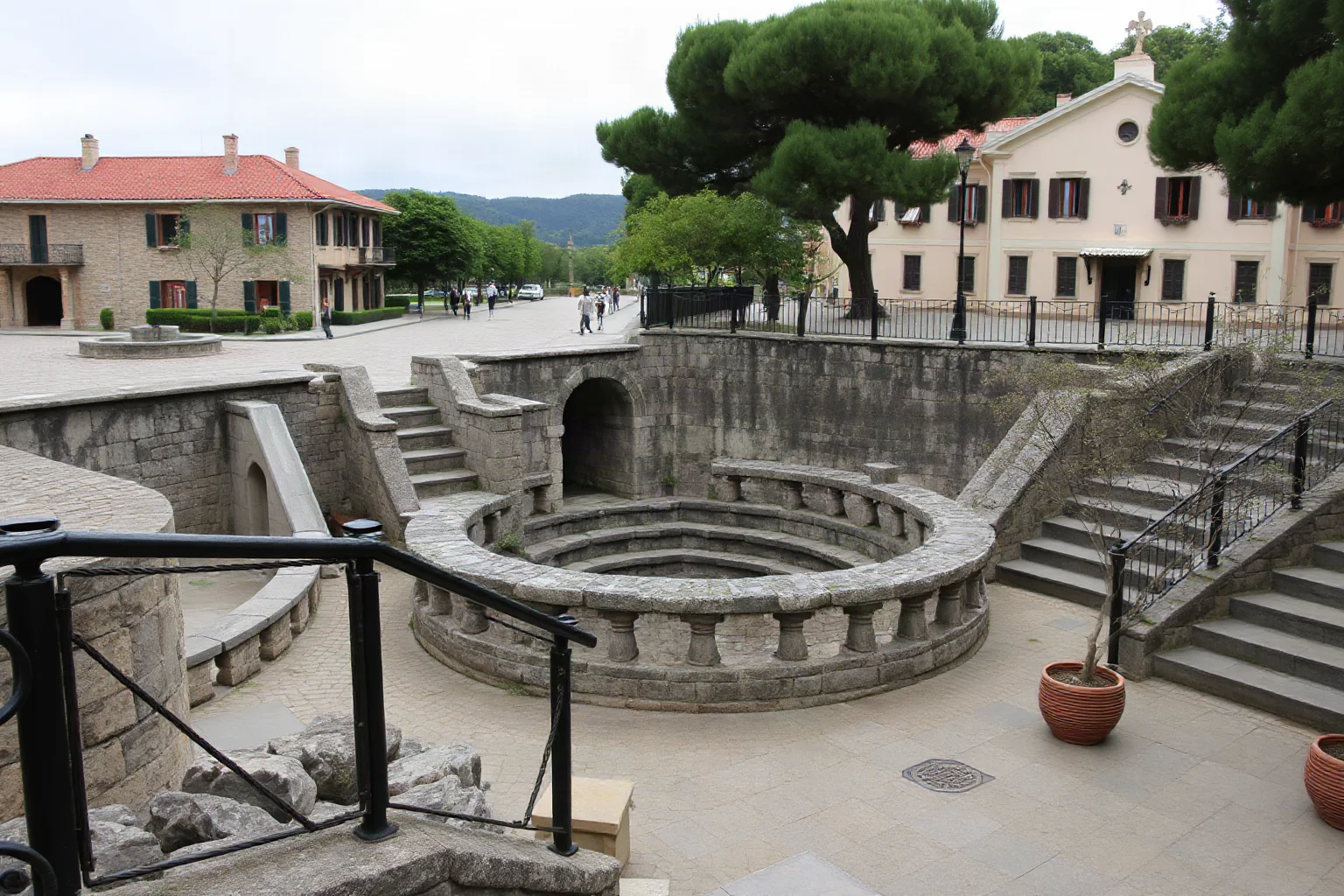 Ancient stone reservoir basin surrounded by paved plaza catchment area