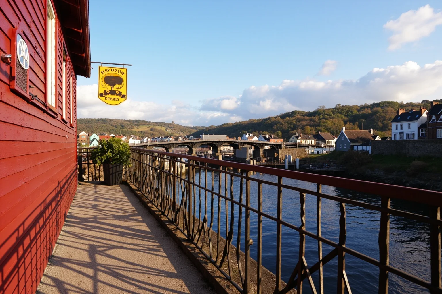 Charming red colonial inn along a river valley with a taproom sign and old shipbuilding town in the background