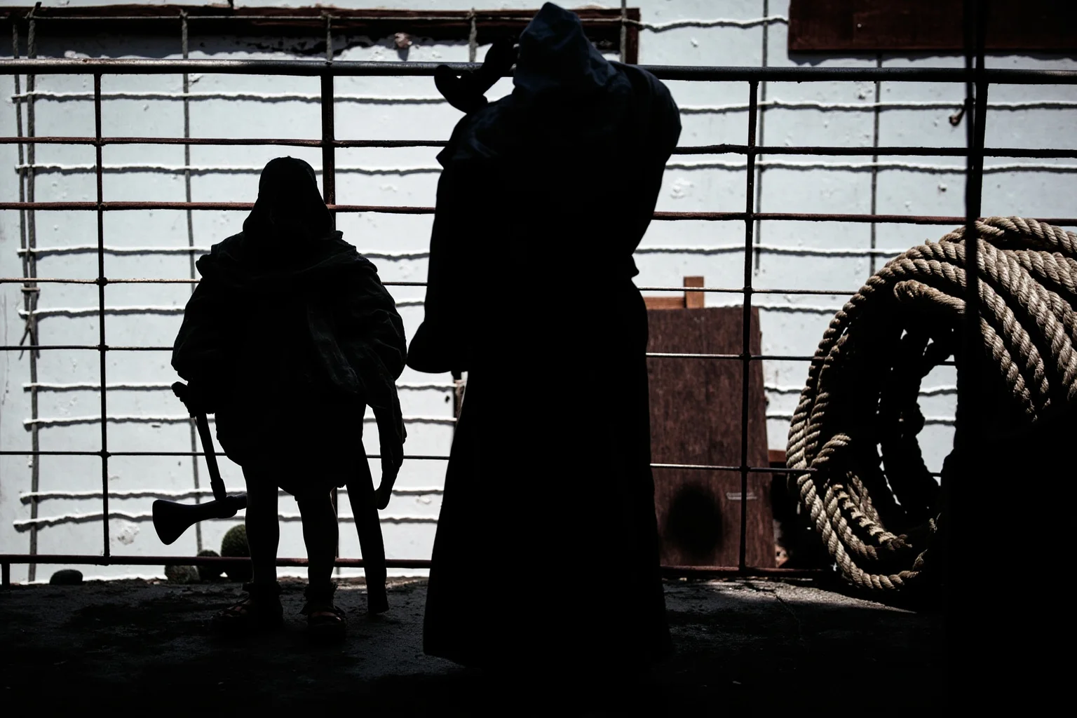 Public Executions Were Once The Most Attended Events In Town — Here's What That Says About Us 10 Cloaked historical figure standing beside a rope coil and axe on a wooden platform, silhouette style