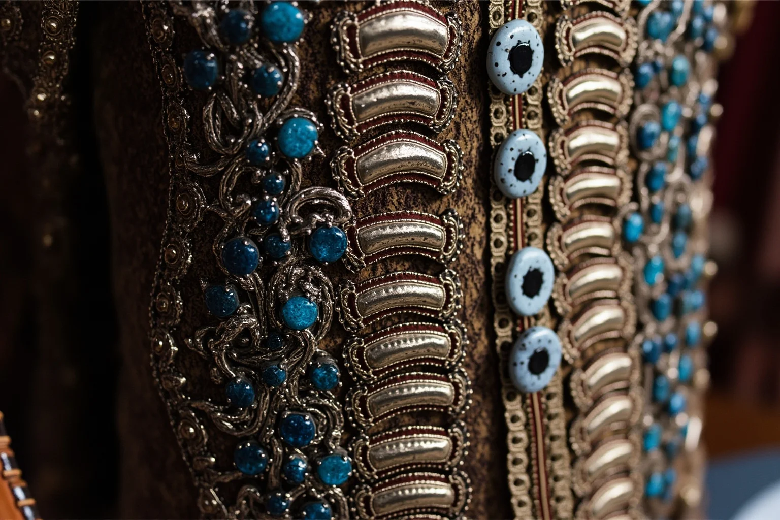 Close-up of an ornate historical coat with rows of decorative silver and gemstone buttons