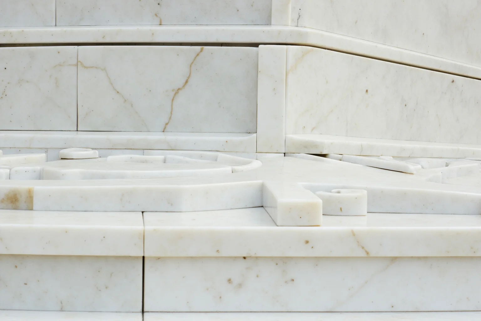 Close-up of gleaming white marble blocks being fitted together on a grand mausoleum facade, historical illustration