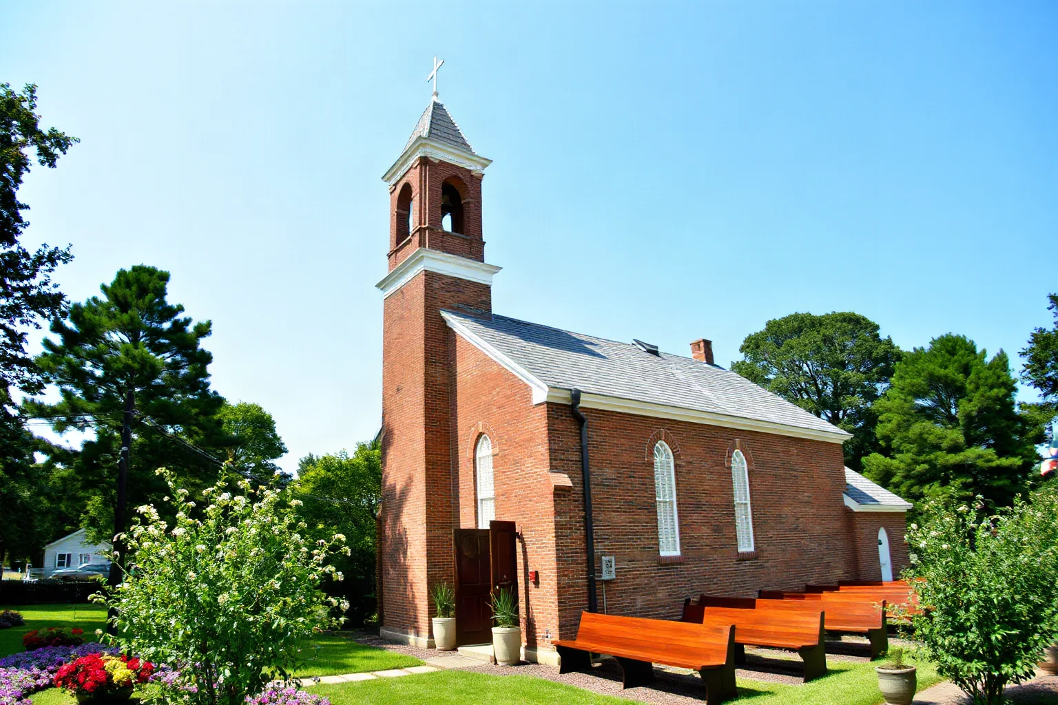 Colonial brick parish church with box pews and a modest bell tower surrounded by manicured gardens