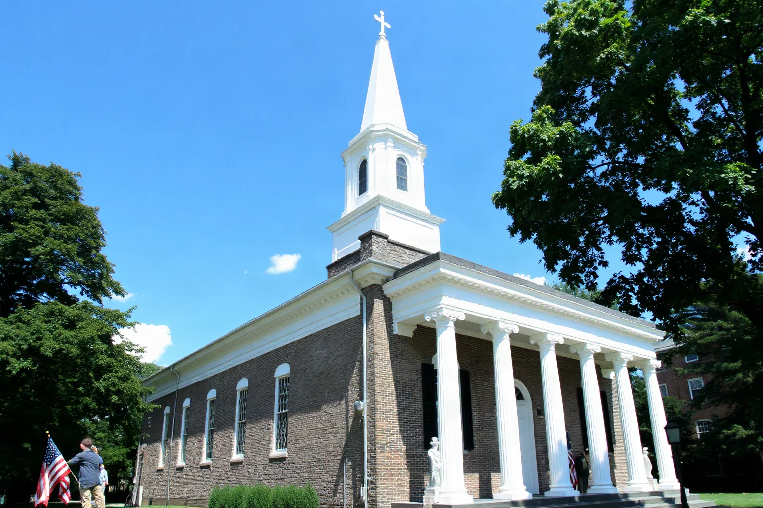 Colonial granite chapel with tall white steeple and classical columns in a historic New England city