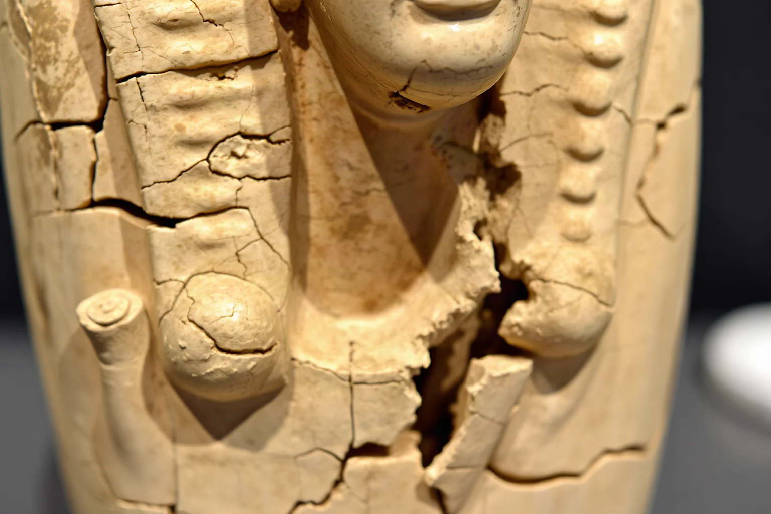 Cracked and chiseled Egyptian statue with a partially removed carved face