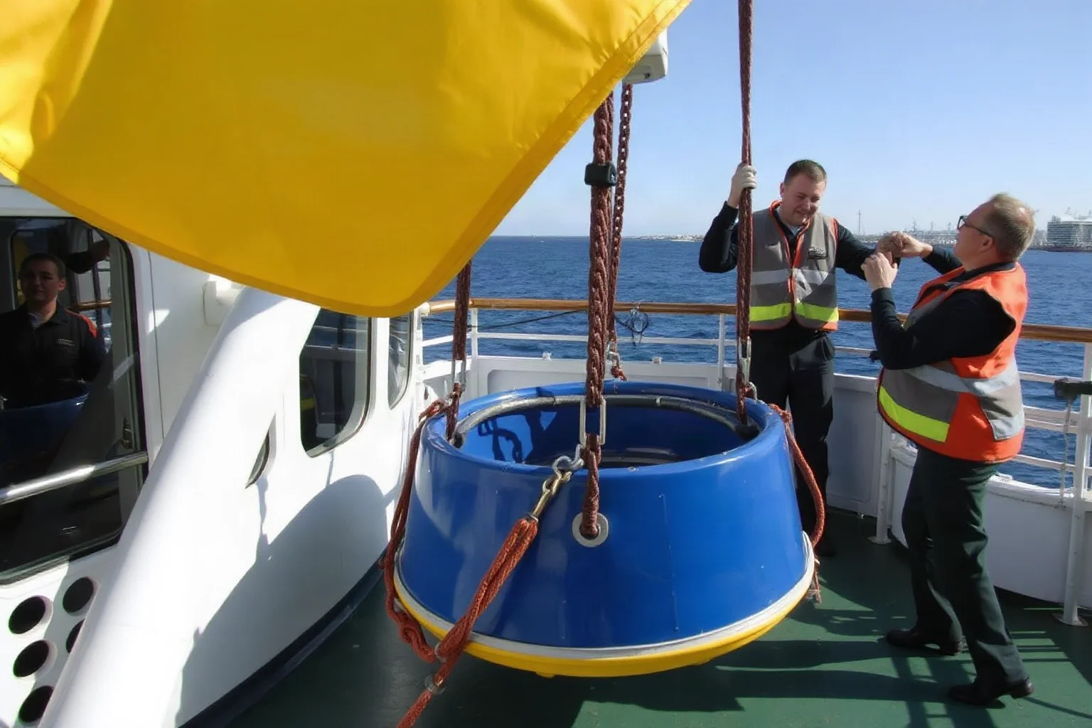 Crew members practicing lowering an empty lifeboat during a safety drill on a liner's deck