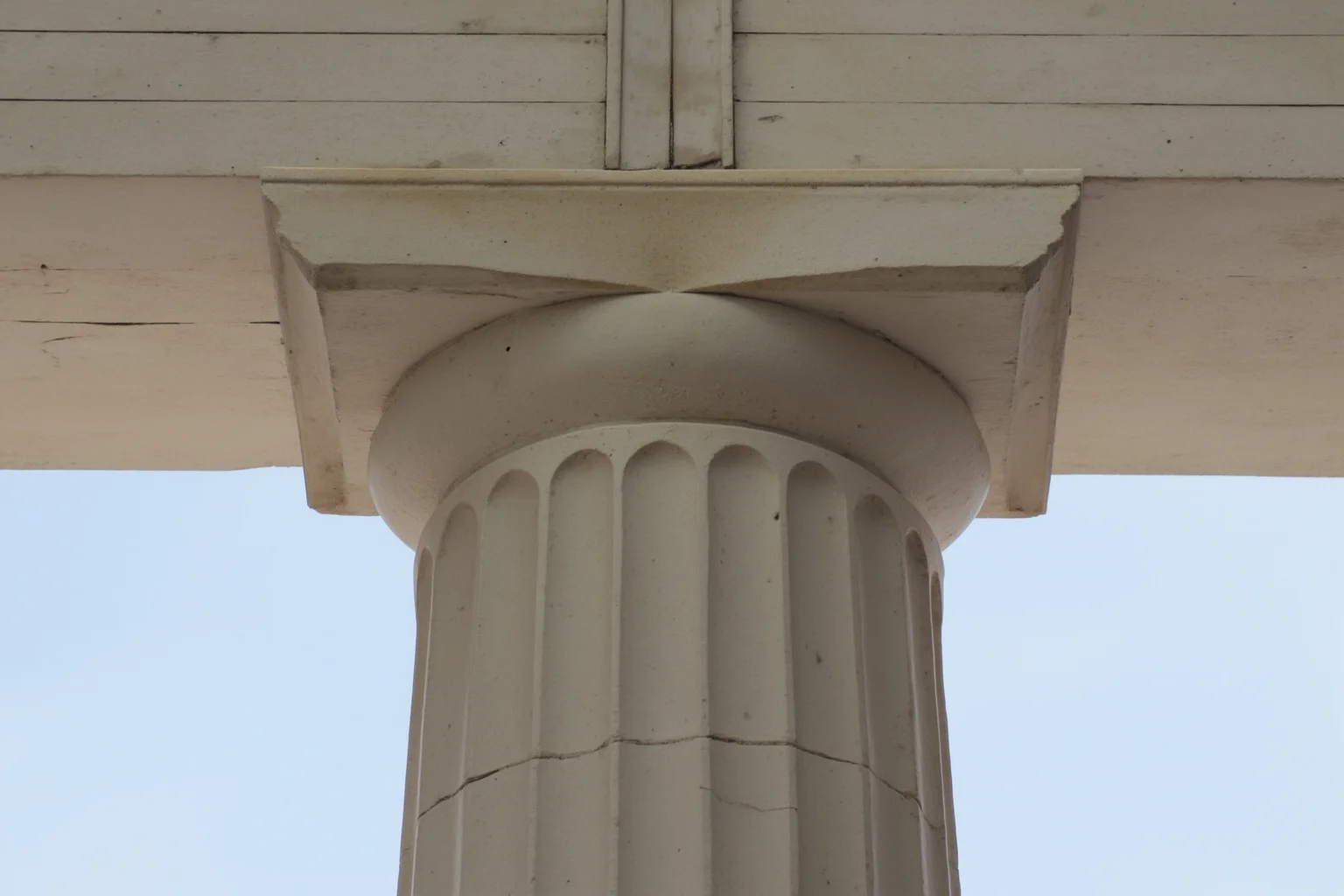 Detail shot of plain, sturdy Doric column capitals supporting a classical marble temple
