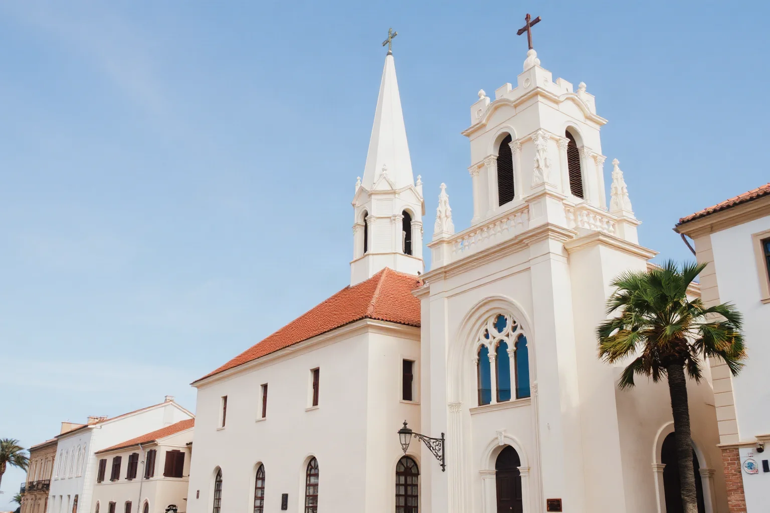 Elegant white steepled church with tall arched windows in a historic Southern coastal city