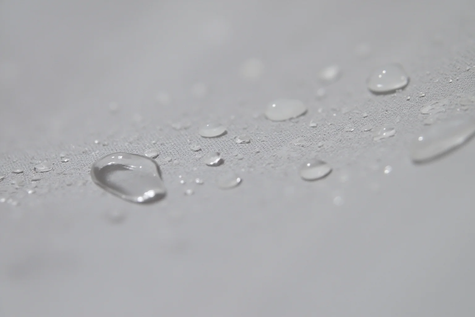 Fabric sample with protective coating repelling liquid droplets, close-up photography