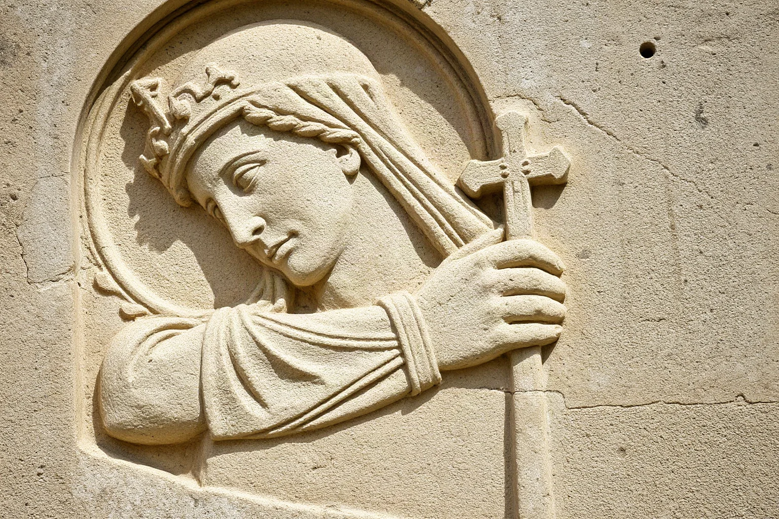 A weathered stone relief carving of a robed early Christian martyr saint, medieval European art style, no modern text