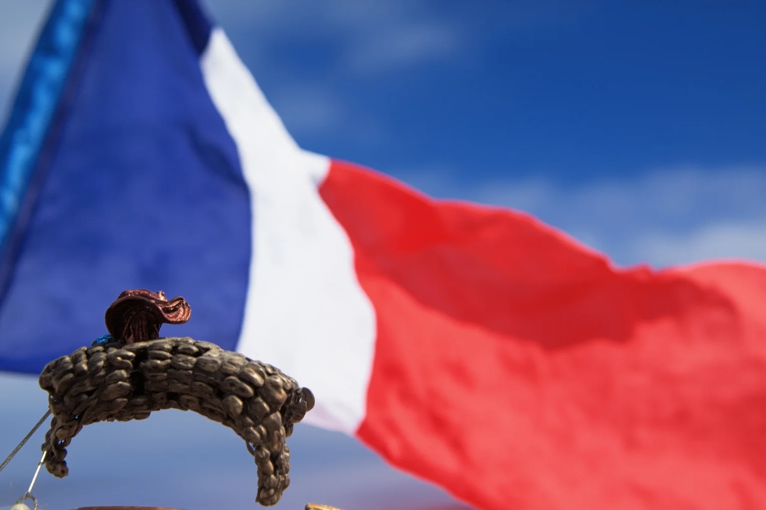 France's blue-white-red tricolor flag with a faint Revolutionary-era cockade illustration nearby