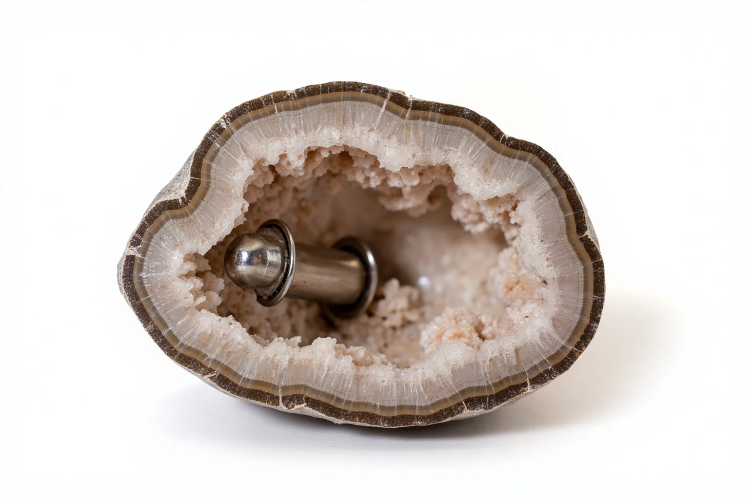 Proof of Time Travel? 20 Famous Photos, Notes, and Stories Fact-Checked 17 Geode rock cut open revealing a small metallic cylindrical object embedded inside, studio lighting