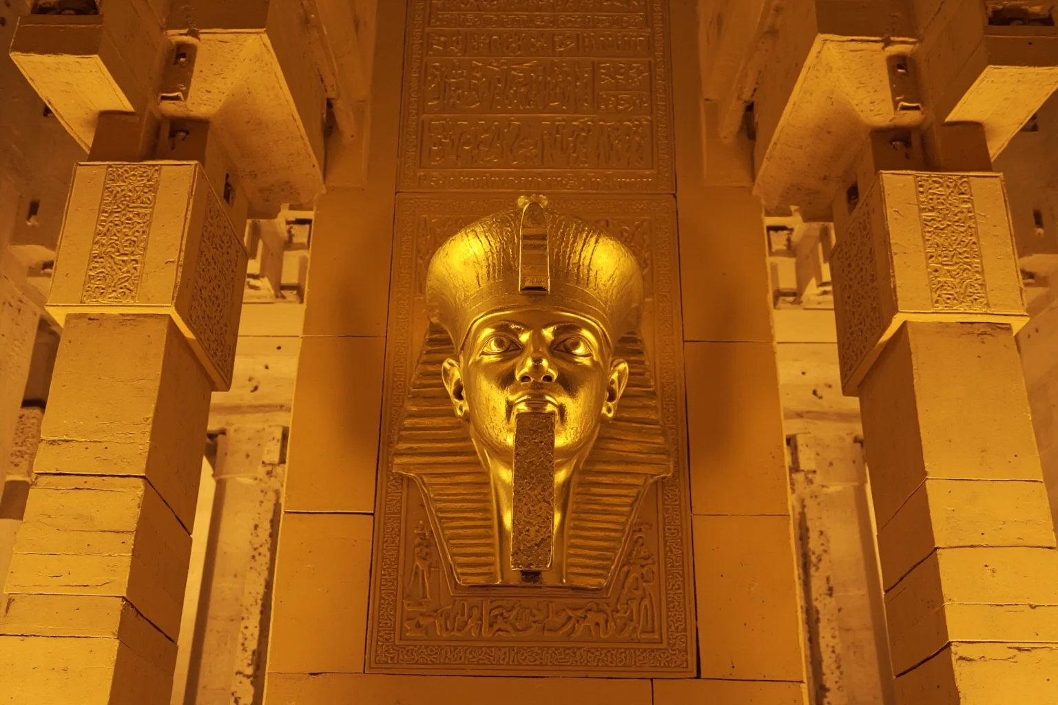 Golden funerary mask and temple columns representing New Kingdom Egypt's monumental architecture