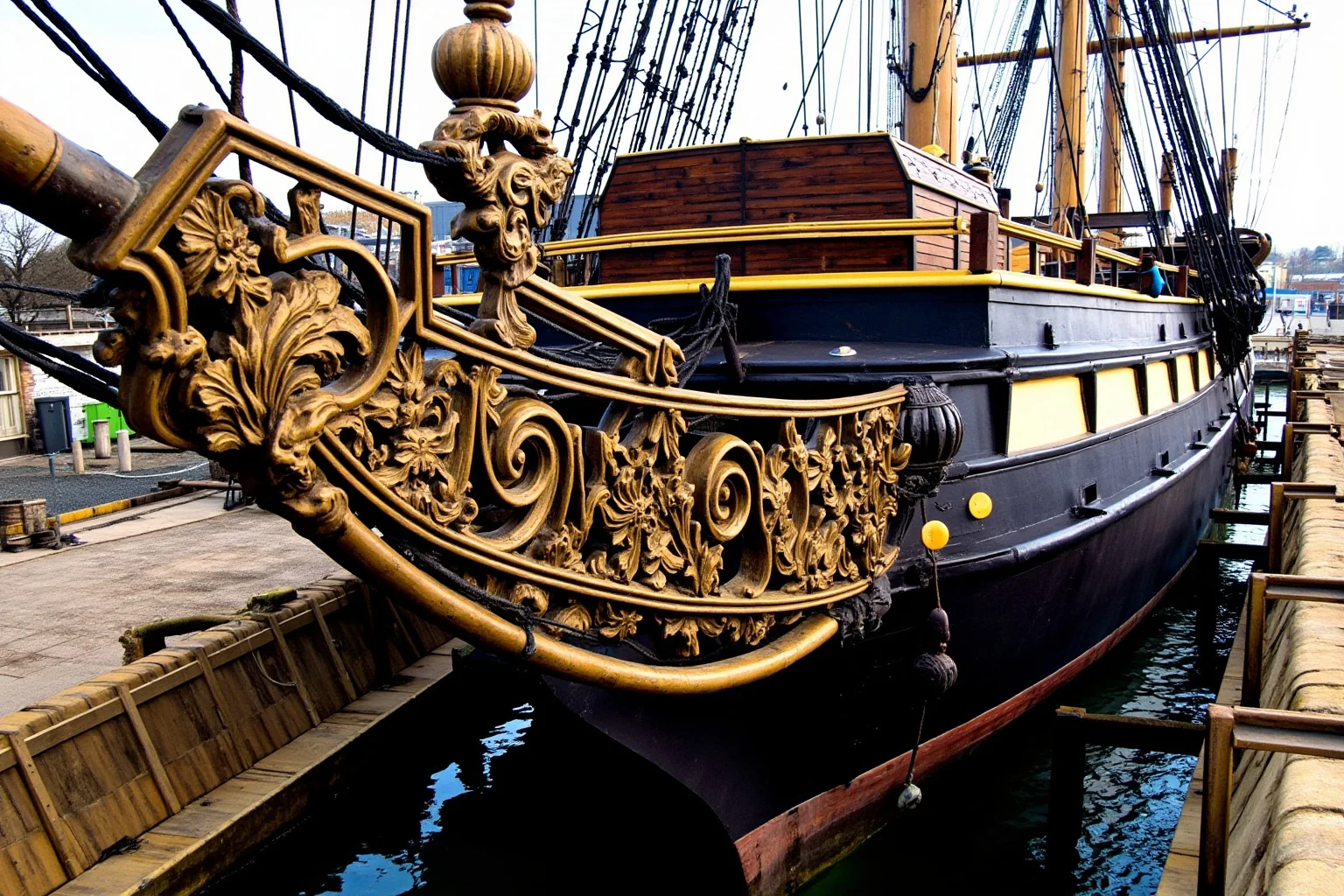 The Longest-Serving Warships of All Time 3 Grand wooden first-rate sailing warship with three gun decks in a British dry dock, ornate stern carvings, historic naval dockyard setting