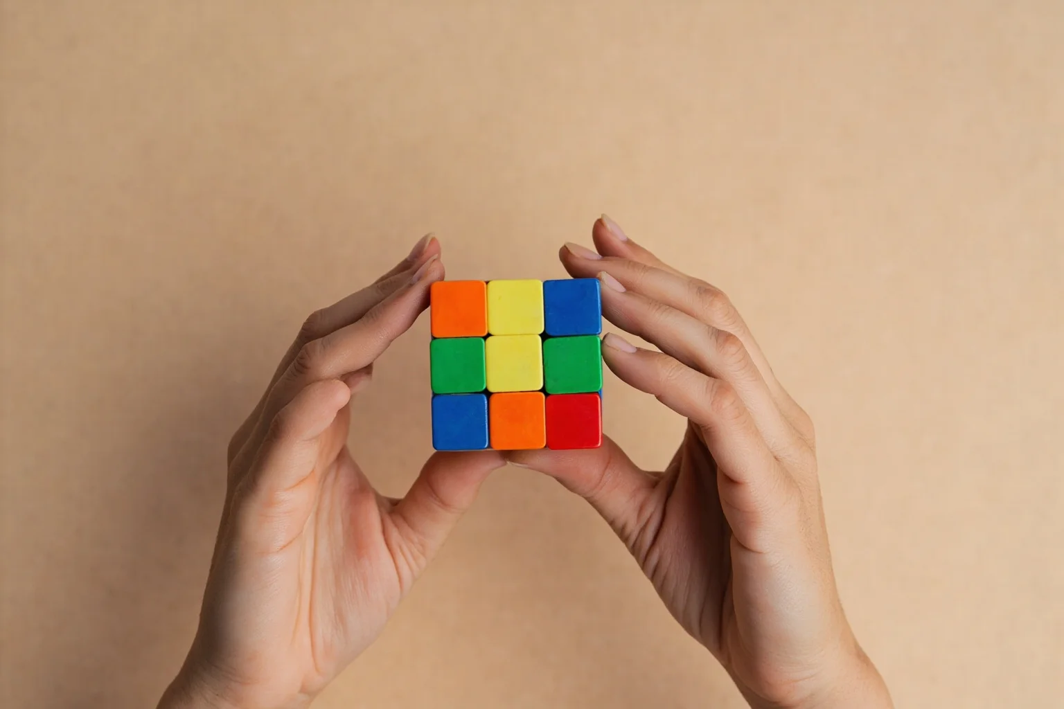 Biggest Fads Throughout American History 25 Hands solving a colorful Rubik's Cube puzzle against a plain background