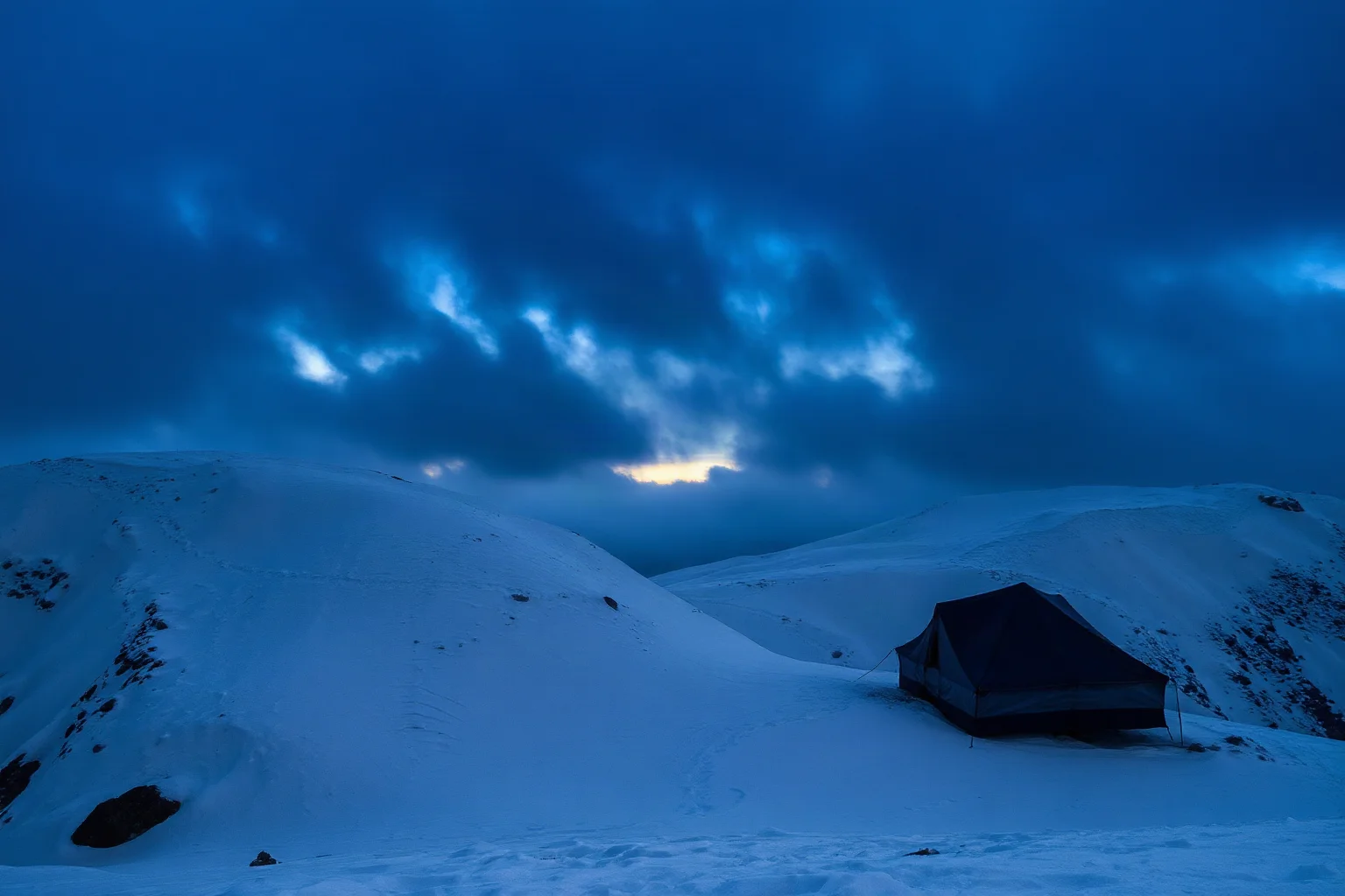A remote, snow-covered mountain pass in the Ural Mountains at dusk, with a lone abandoned tent visible on a wind-swept slope, moody and atmospheric, no people visible