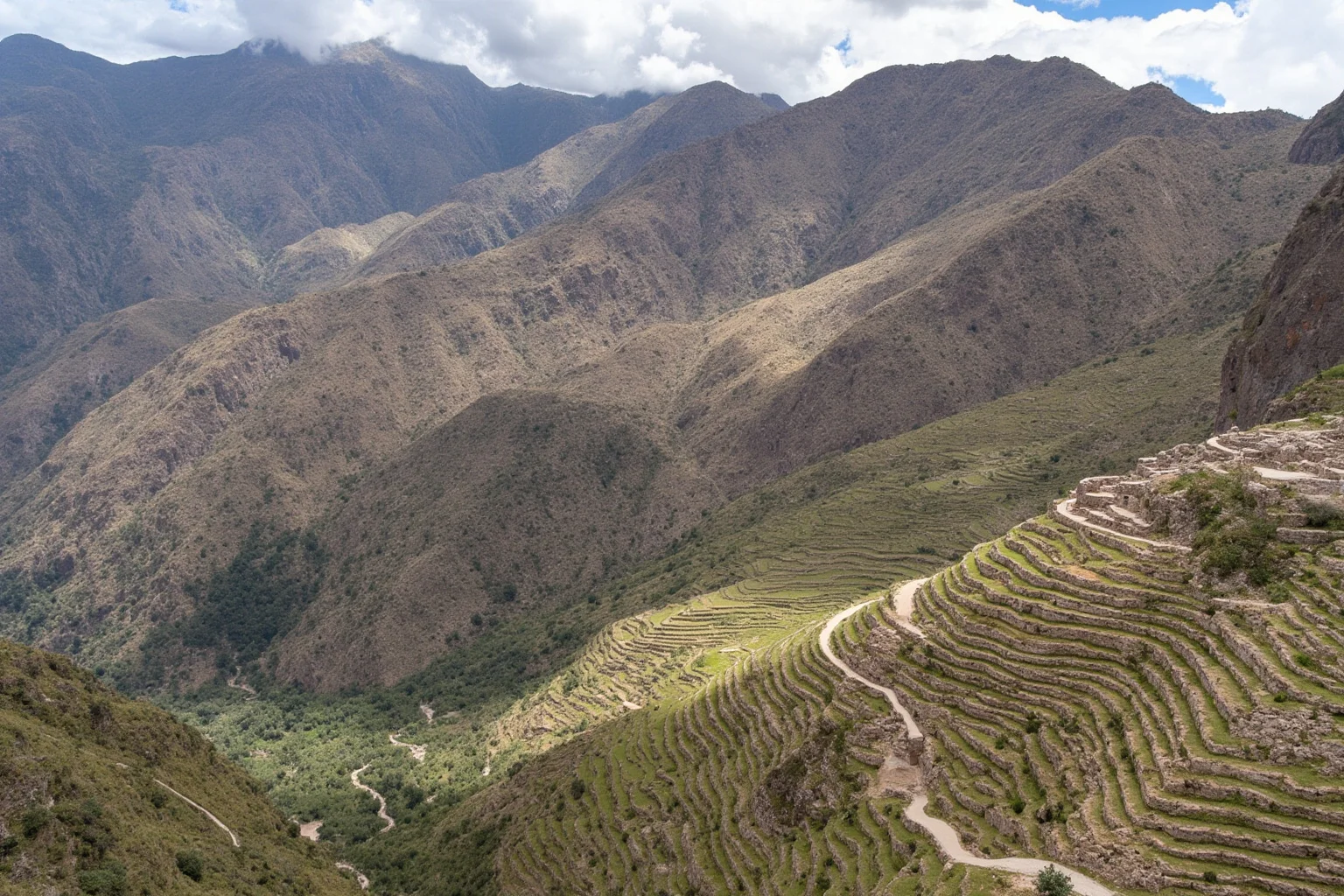 Inca stone terraces and mountain road winding through the Andes near Cusco