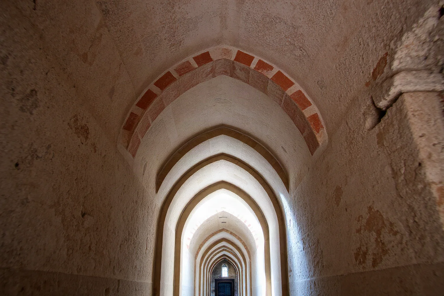 Interior view of an ancient stone corridor with a stepped corbeled arch ceiling