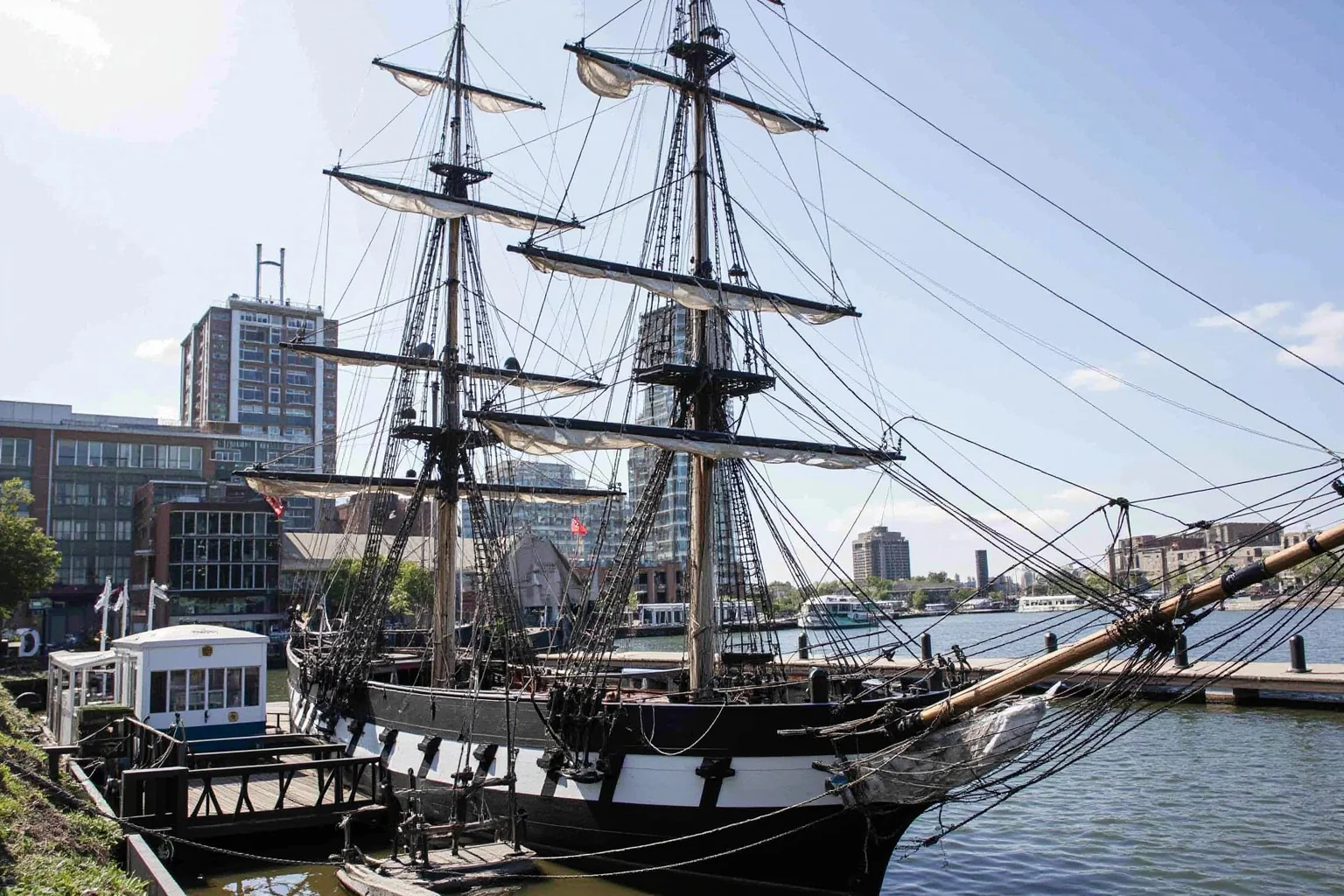The Longest-Serving Warships of All Time 6 Mid-19th-century wooden sloop-of-war with white and black hull, docked at an urban harbor museum setting