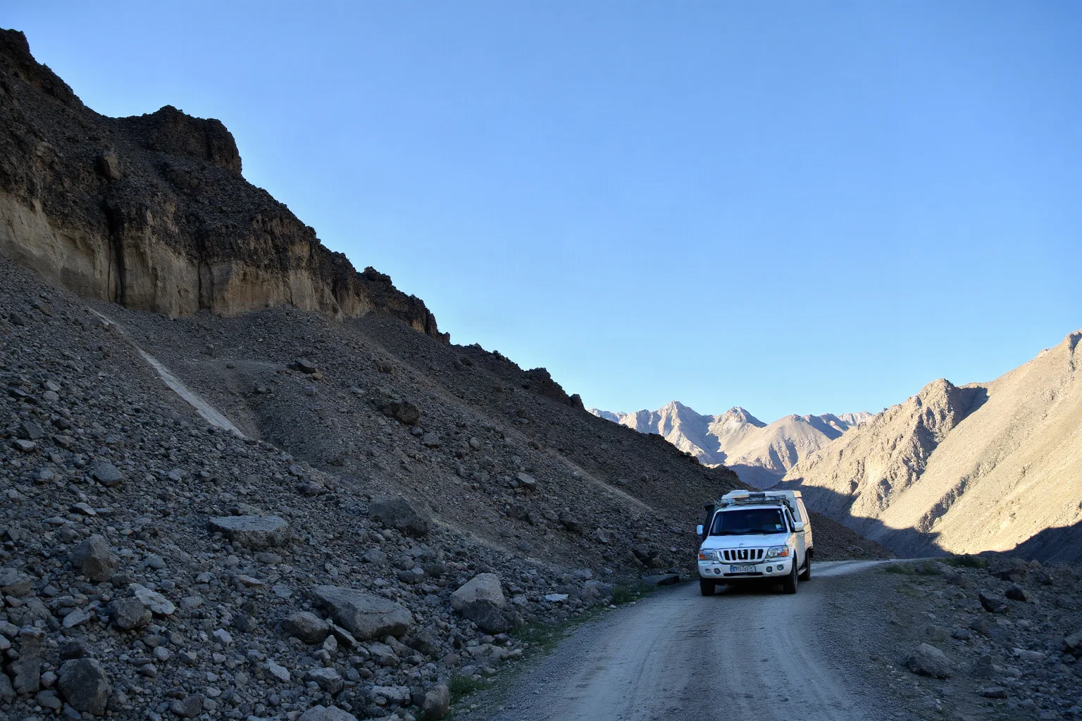 Mountainous Afghan terrain with a rugged convoy path winding between rocky cliffs