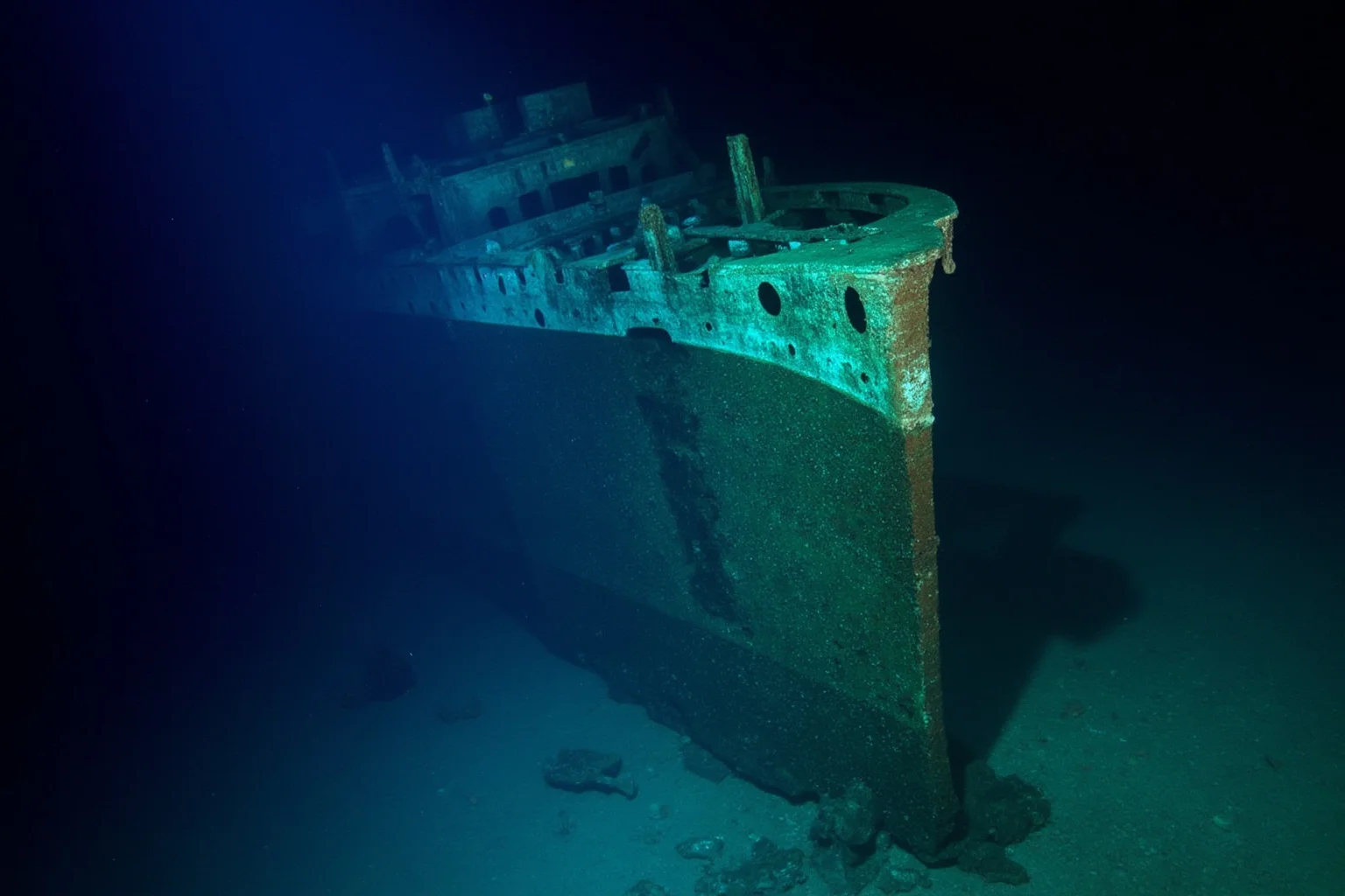 22 Coolest Underwater Discoveries Made Throughout History 22 Ocean liner wreck resting on its side on the seafloor, illuminated by a diving expedition's lights
