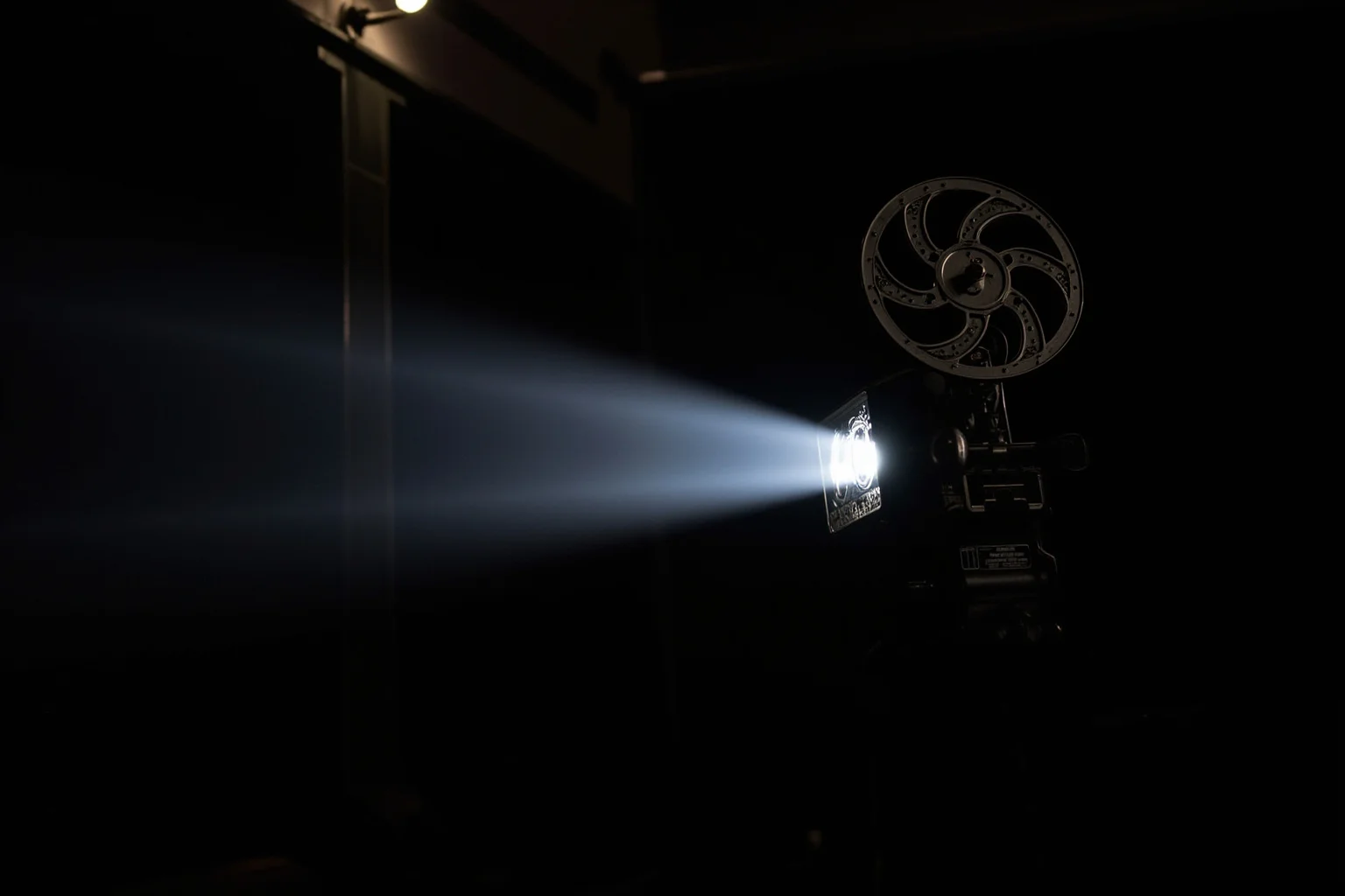 Inventors Who Stole Genius Ideas And Got All Glory 16 Old-fashioned movie projector beaming light across a dark vintage theater room
