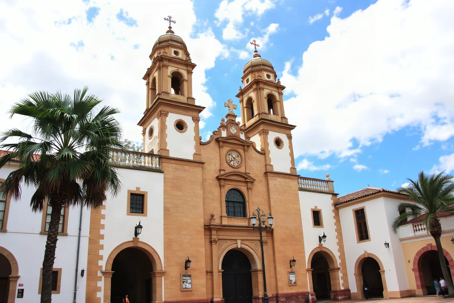 Ornate Spanish colonial cathedral facade with bell towers in a historic Florida town square