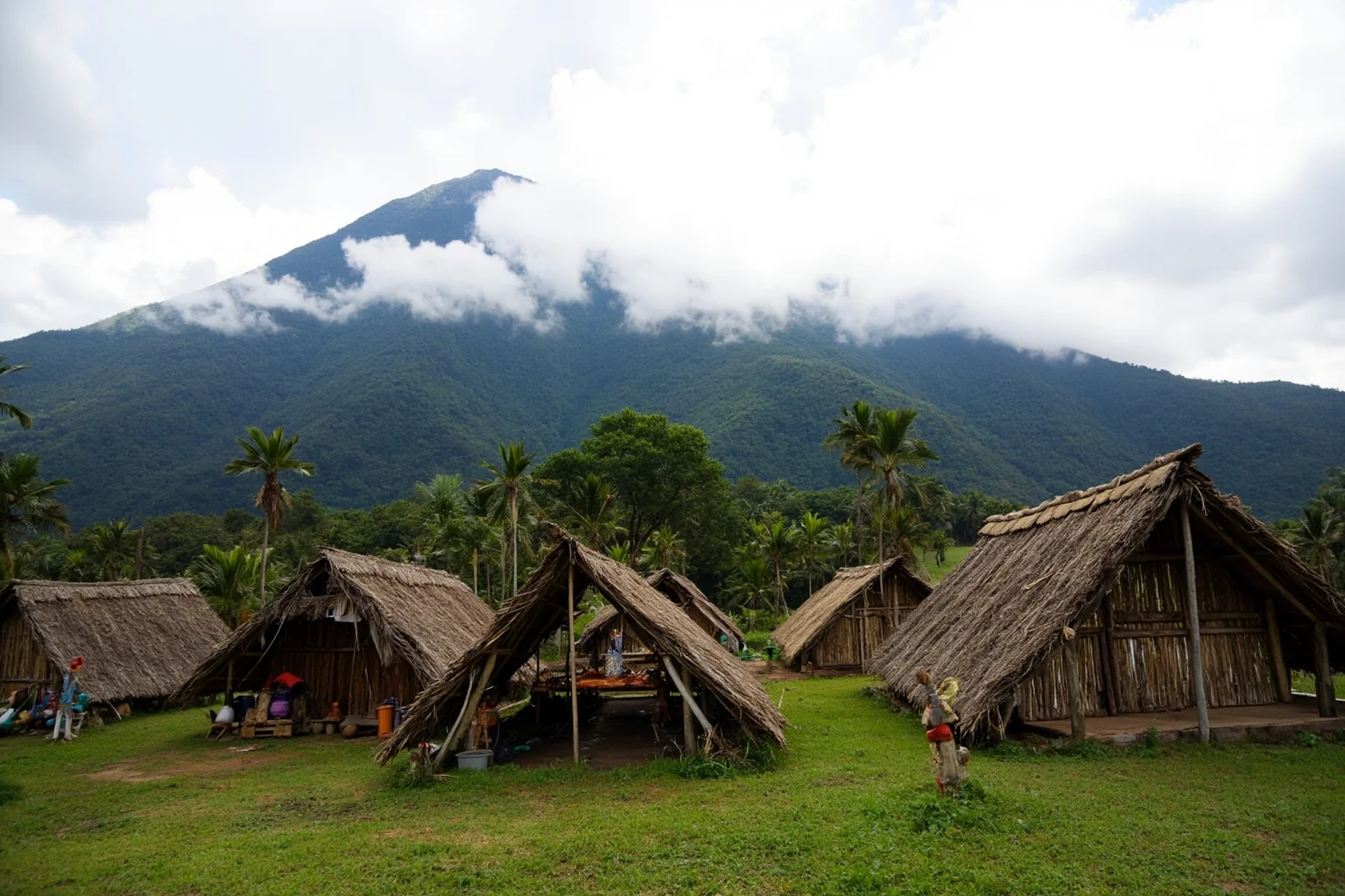 Papua New Guinea highland village with traditional thatched huts and misty mountains in the background
