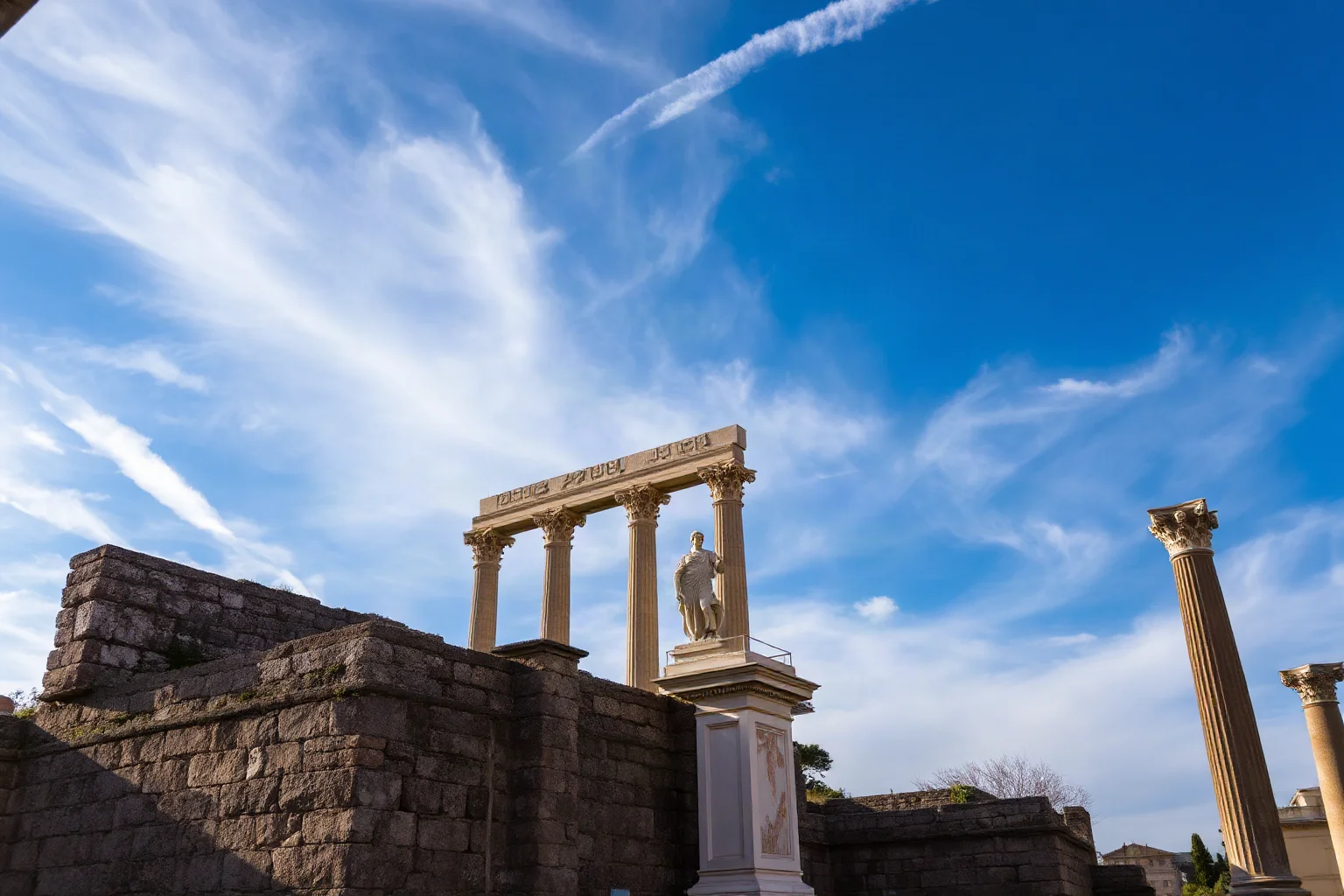 Roman forum ruins with a statue of Jupiter, classical marble architecture, dramatic sky
