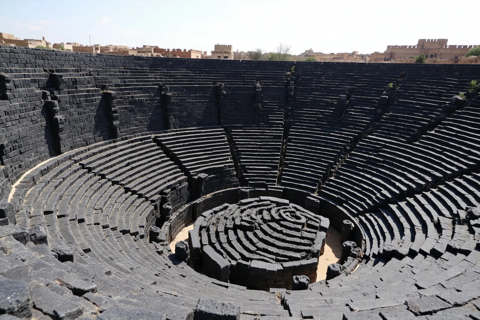 Roman theatre of Bosra in Syria built from dark black basalt stone with a fortress-like surrounding wall