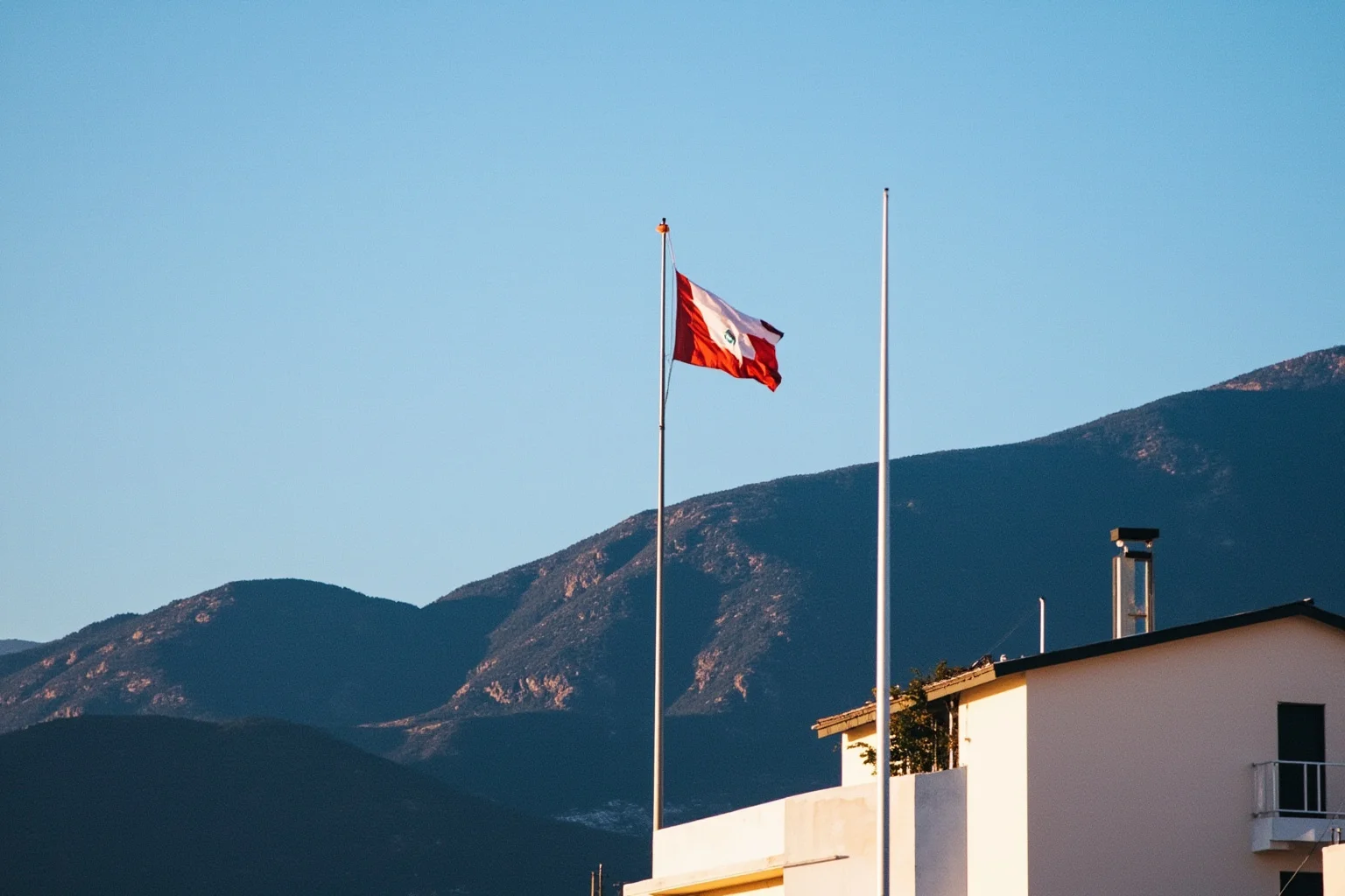 Countries With the Longest Histories (and 10 With the Shortest) 27 Simple modern government building with a new national flag against a mountain backdrop