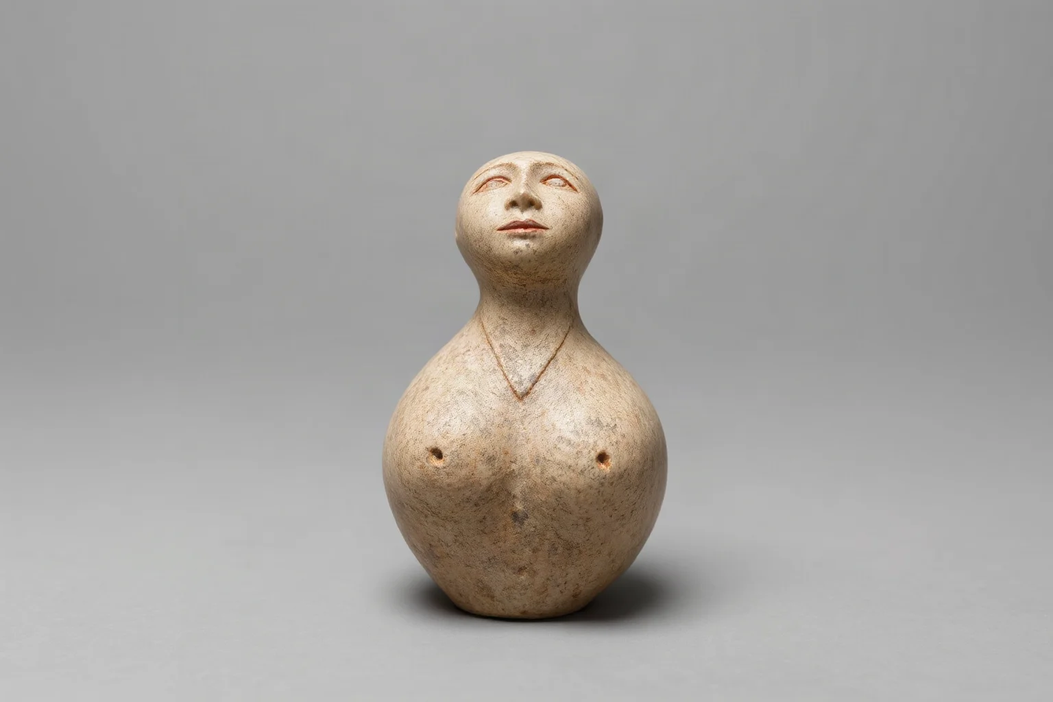 Small limestone figurine with rounded exaggerated human female proportions, prehistoric sculpture texture