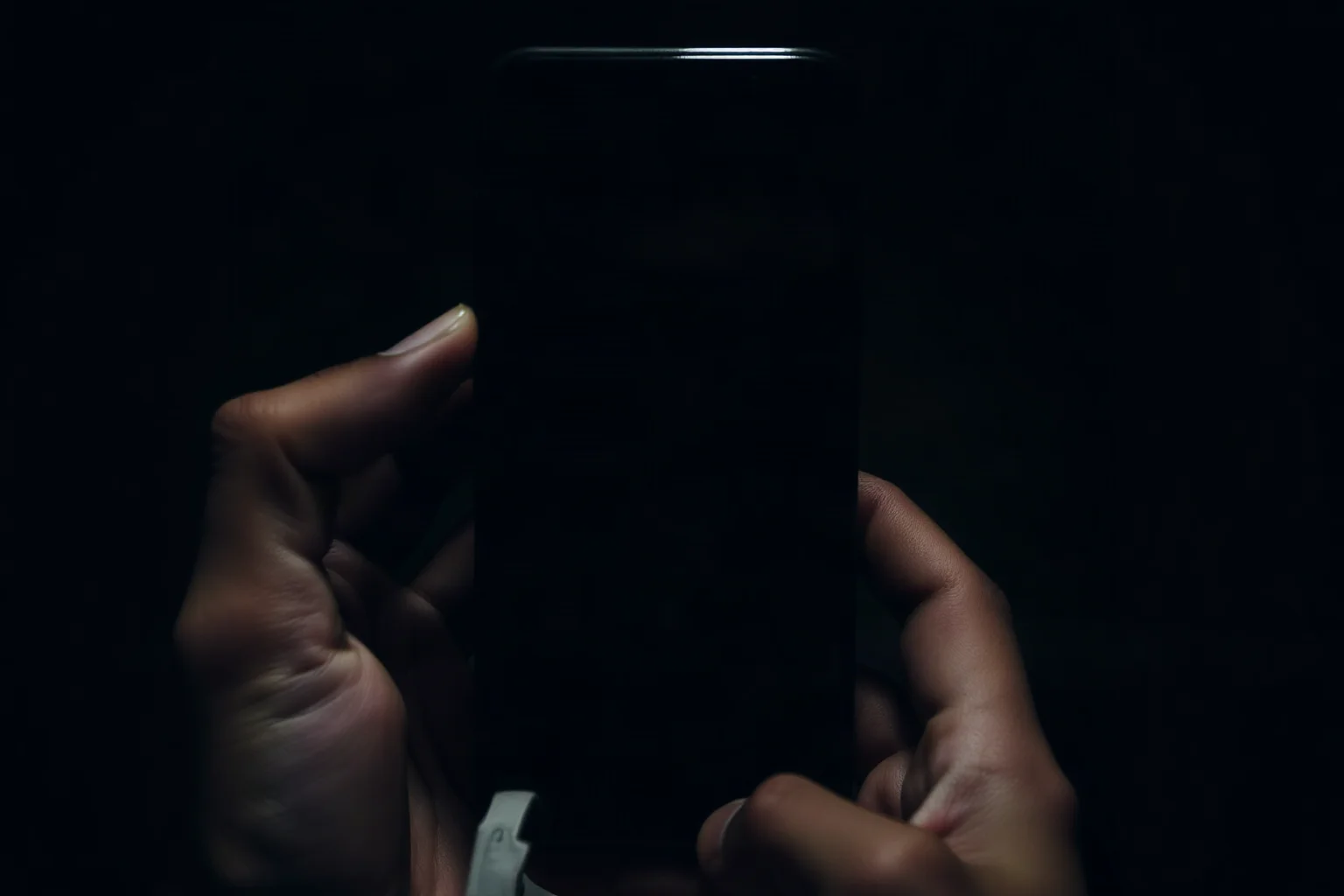 Smartphone screen glowing in the dark held by unseen hands, abstract unsettling imagery, no real logos