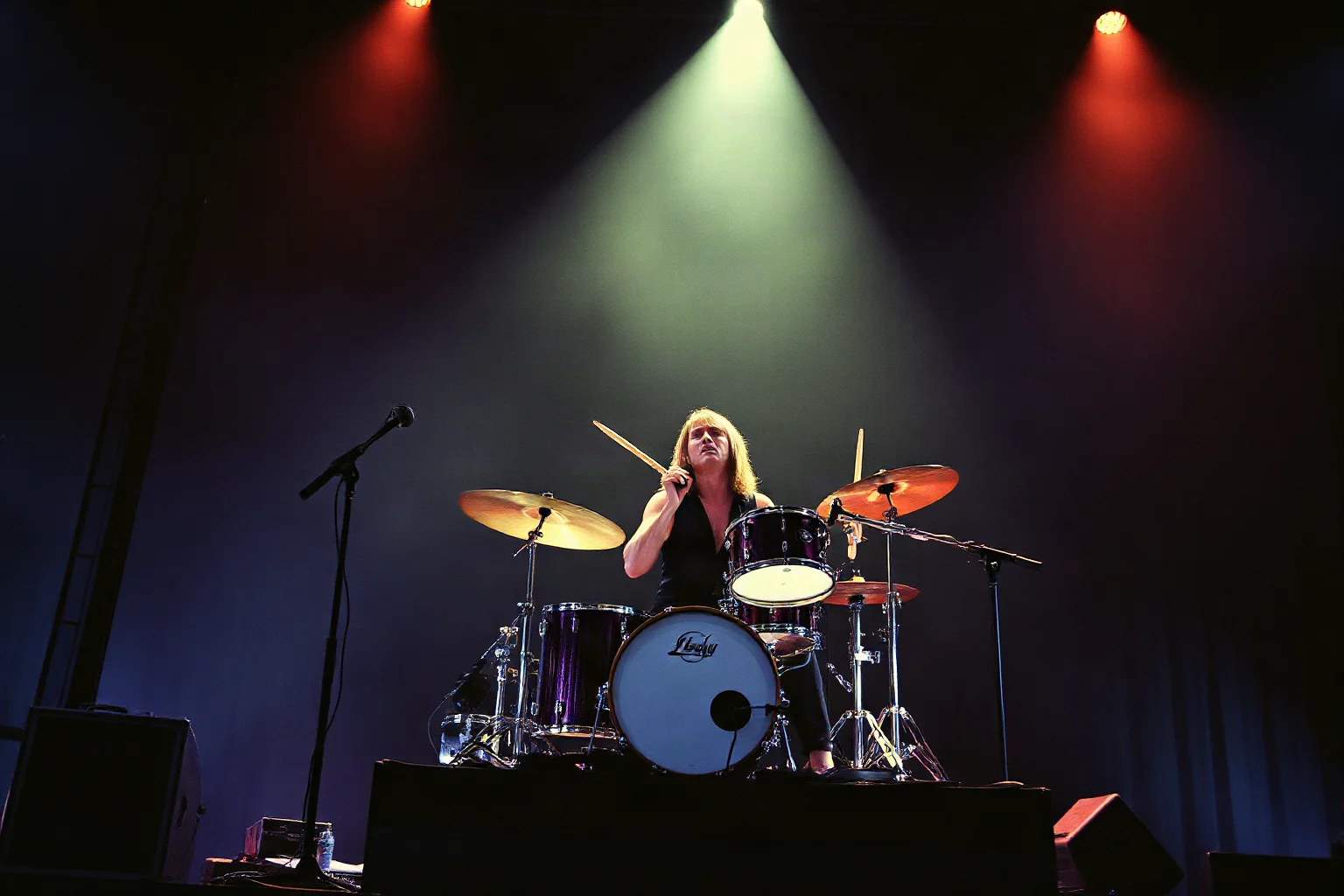 A powerful drummer mid-performance on a dimly lit 1970s rock stage, dramatic stage lighting, illustrated style