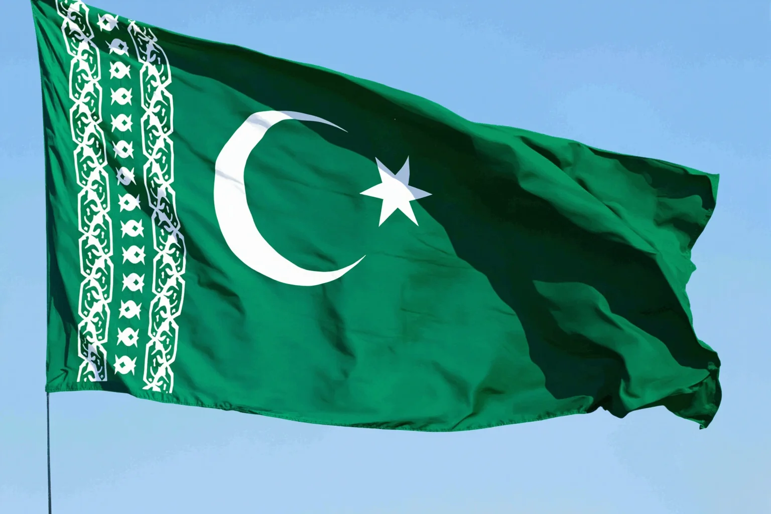 Turkmenistan's green flag with intricate carpet-pattern guls and crescent moon and stars