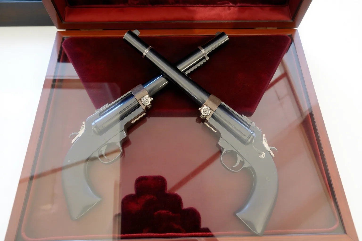 Two antique dueling pistols crossed on a velvet display case, historical illustration