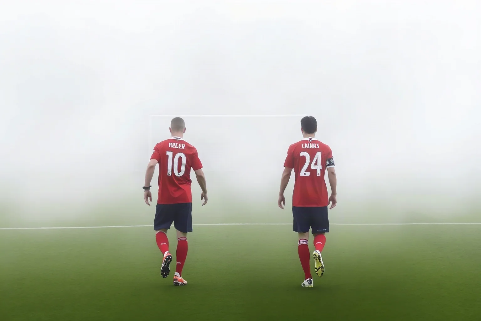 Two English soccer teams in red and red-and-black kits walking onto a foggy pitch, illustrative style