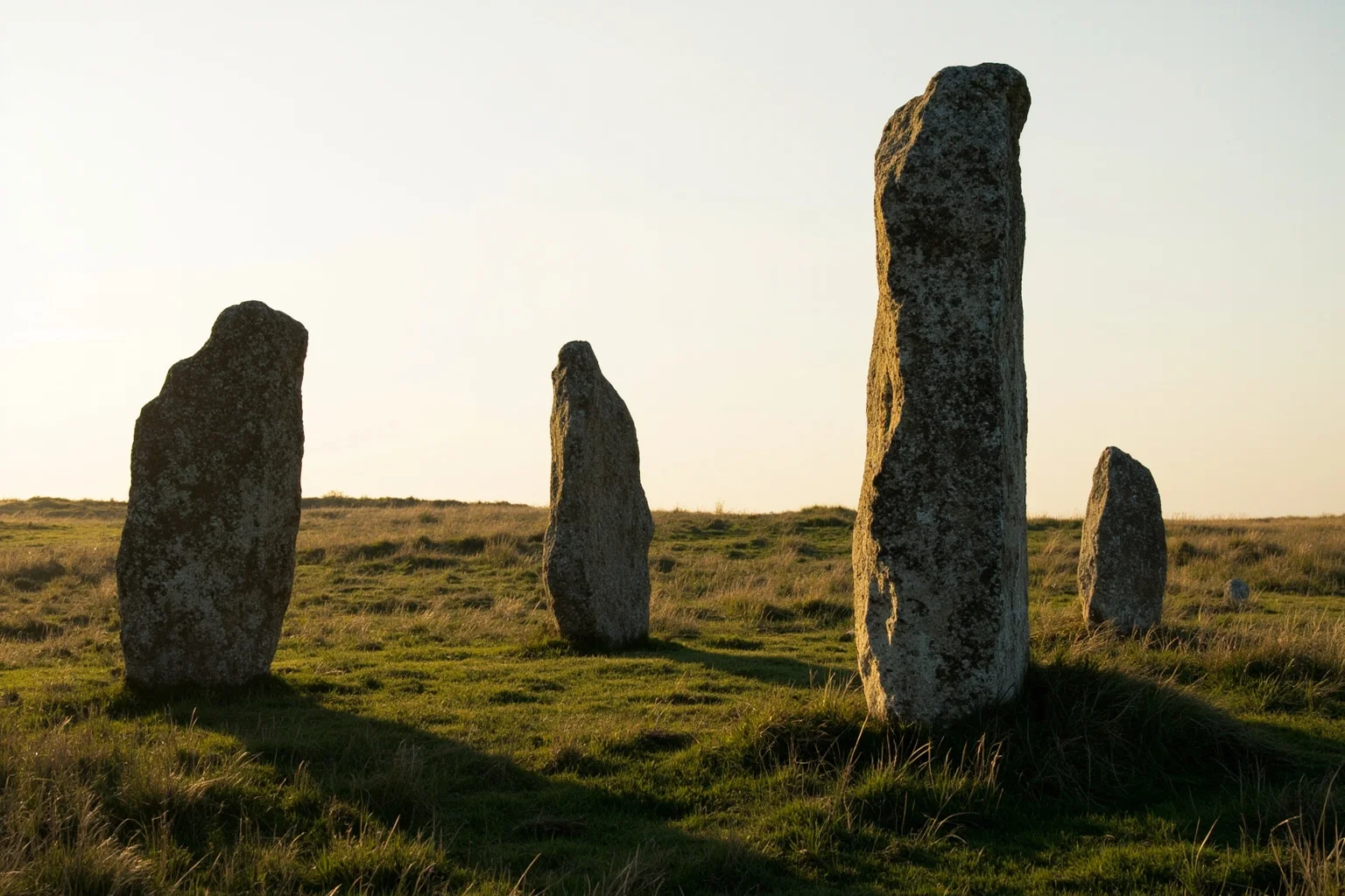 Viking-era rune stones standing in a grassy Danish field under soft light