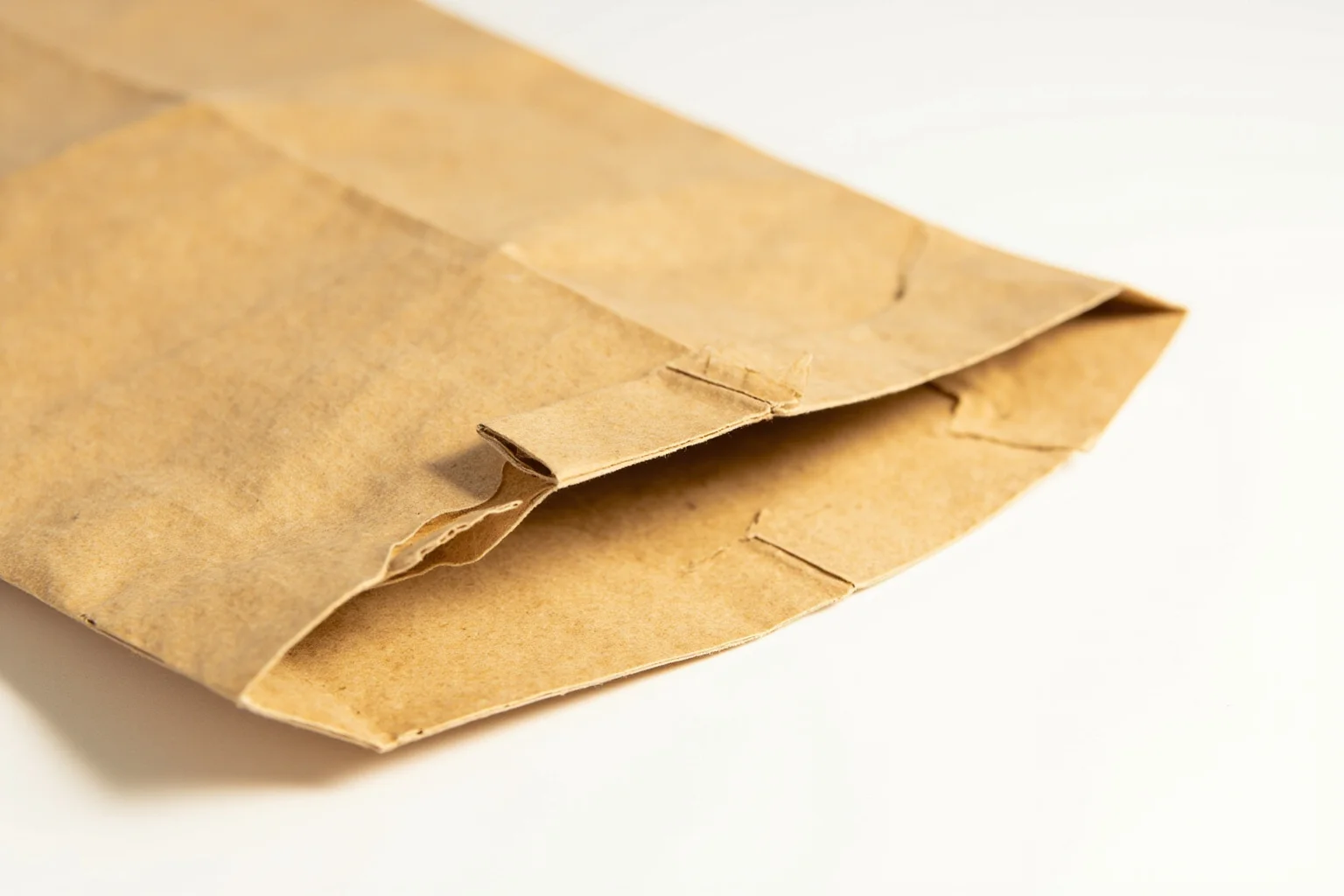 Vintage flat-bottomed paper grocery bag, close-up showing construction and fold
