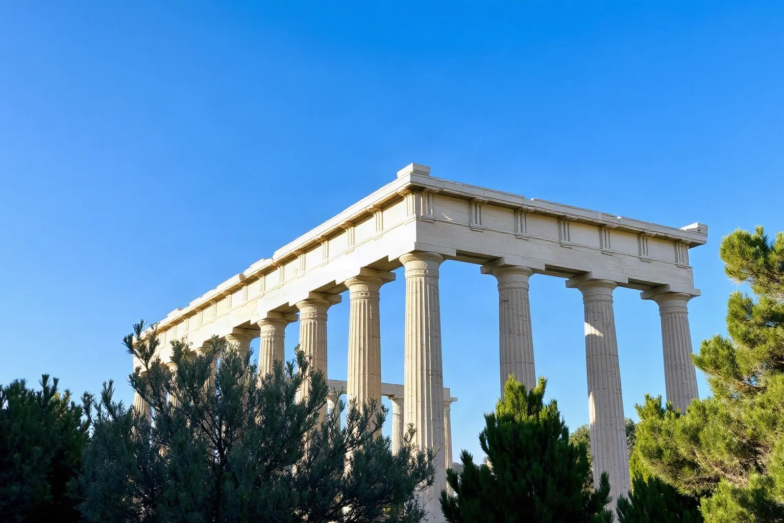 Well-preserved Doric temple of Hephaestus surrounded by green trees in Athens