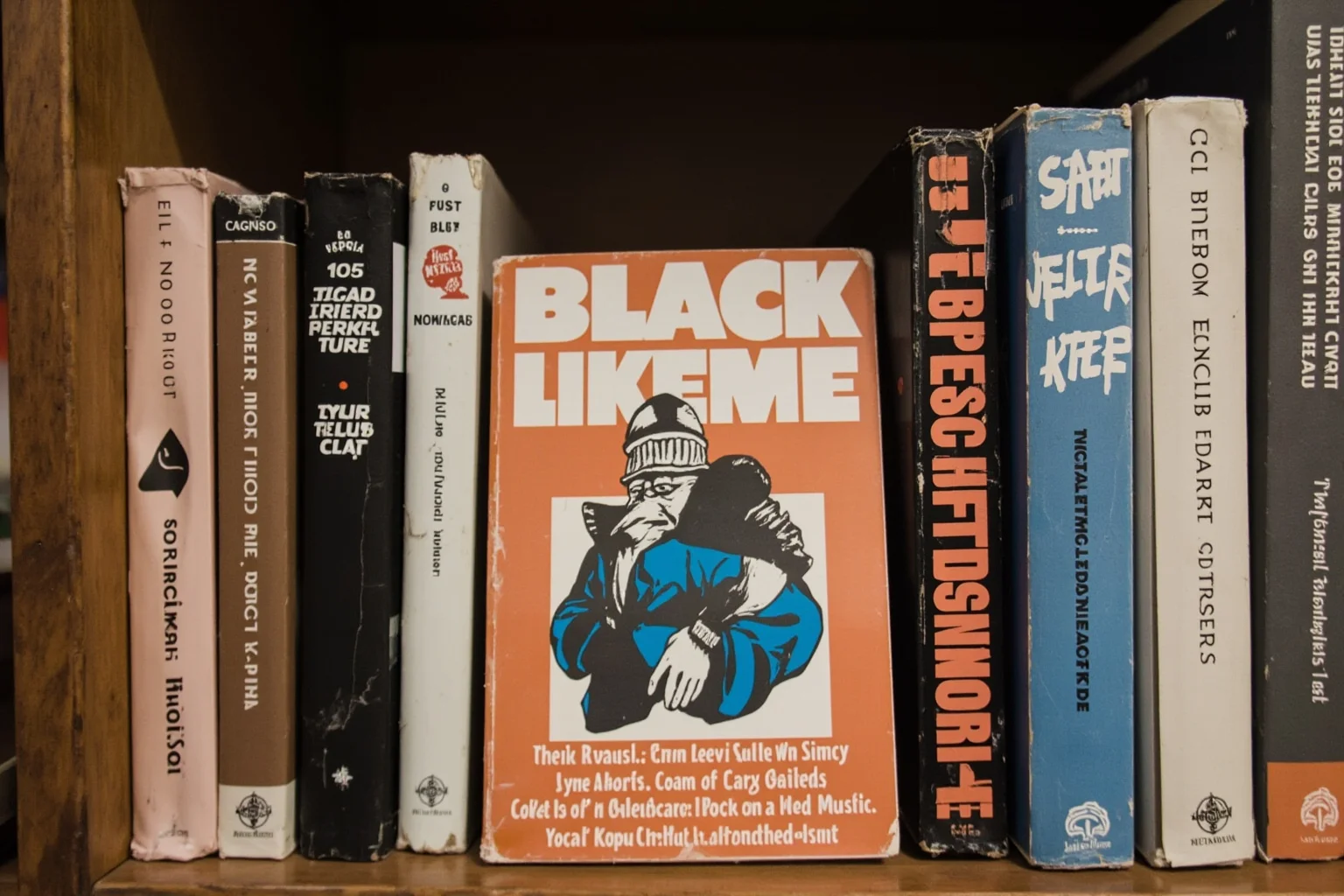 A collection of vintage books on a shelf, with Black Like Me in the center and other titles beside it.