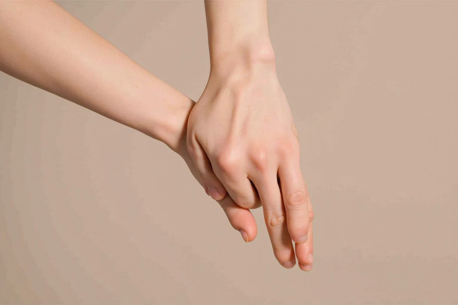 Things To Learn About The Beloved Princess Diana 11 A pair of hands clasping another pair of hands in a supportive gesture, close-up, soft neutral background, no faces visible.