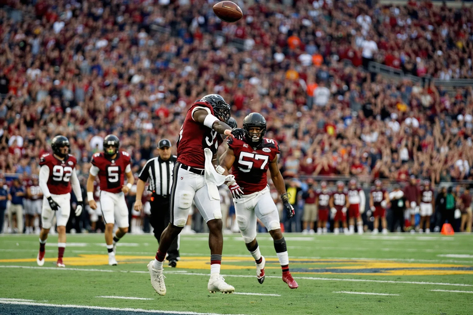 A pick-six return down the sideline in a championship game, generic uniforms, no real logos or names, crowd erupting.